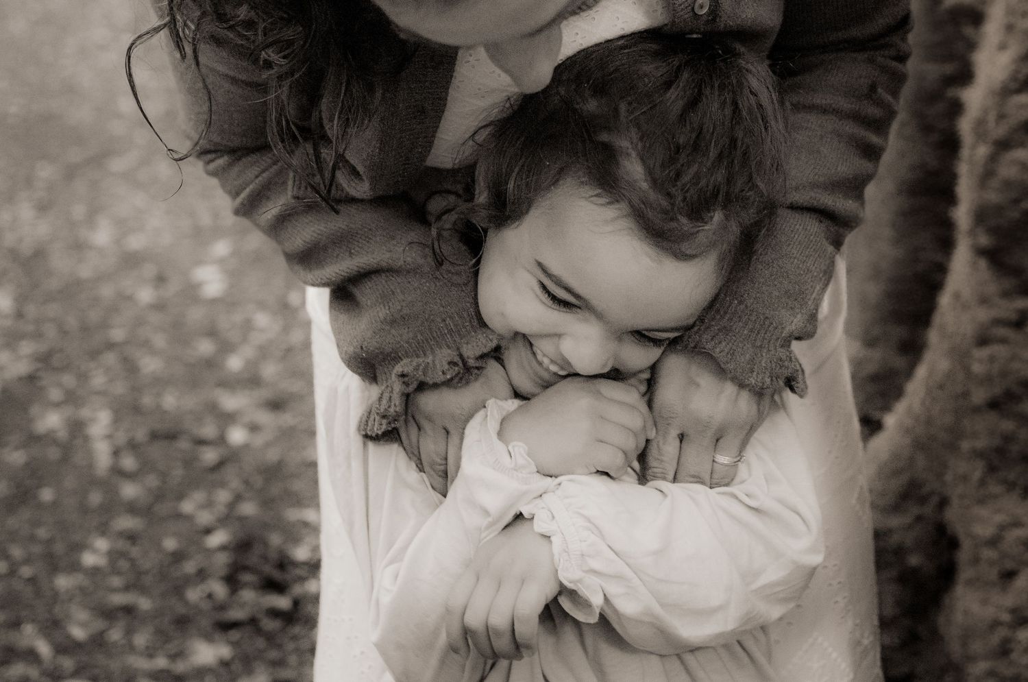Mum cuddling her young daughter during a family photoshoot in Micheldever Woods