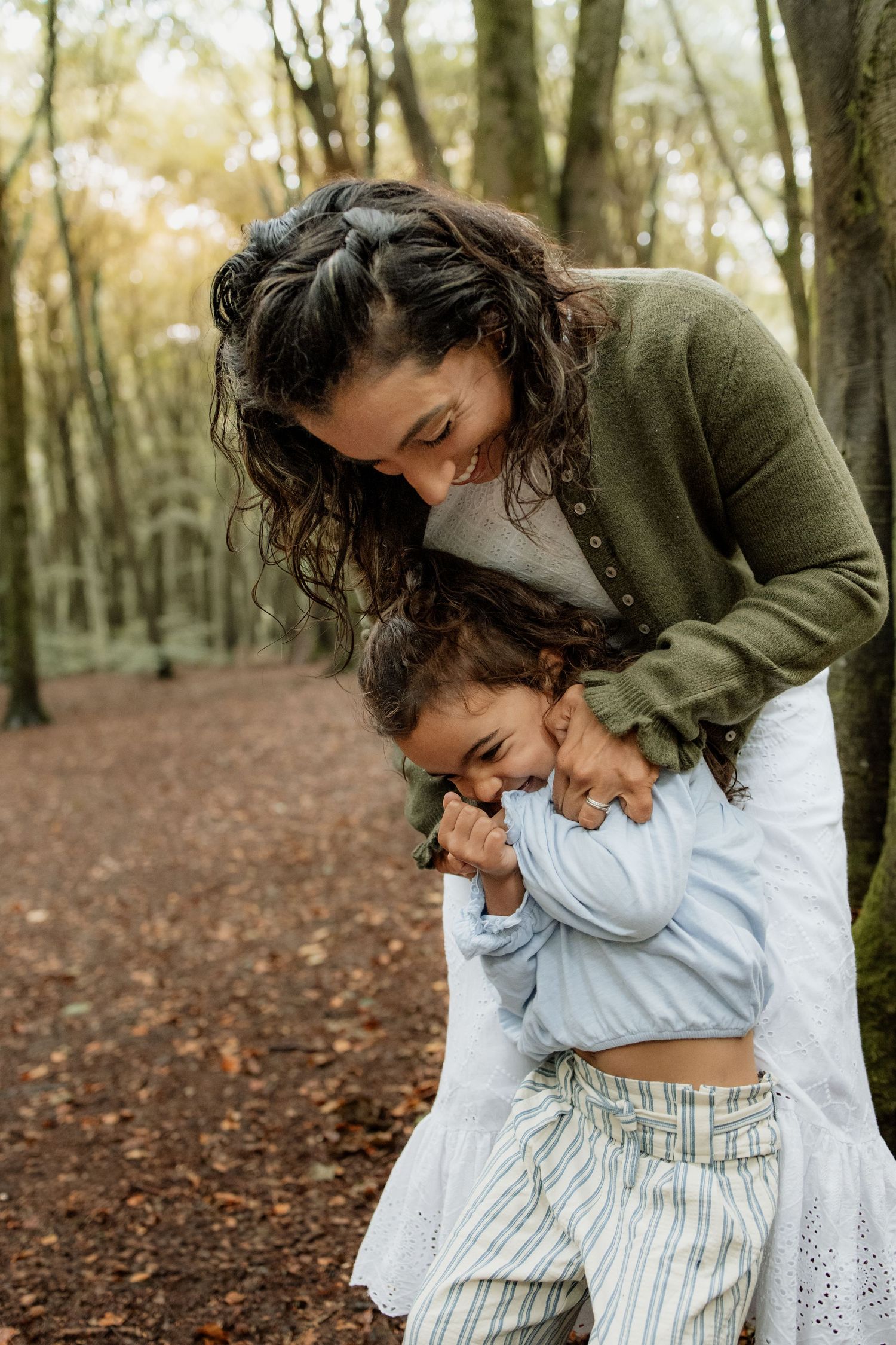 Mum cuddling her young daughter during a family photoshoot in Micheldever Woods