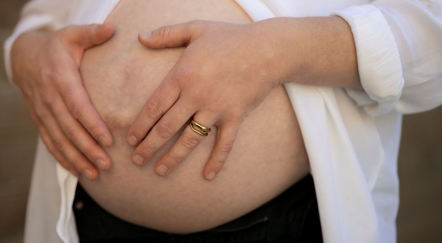 Mum to be holds her pregnant tummy during an at home photoshoot in Kingsworthy near Winchester, hampshire