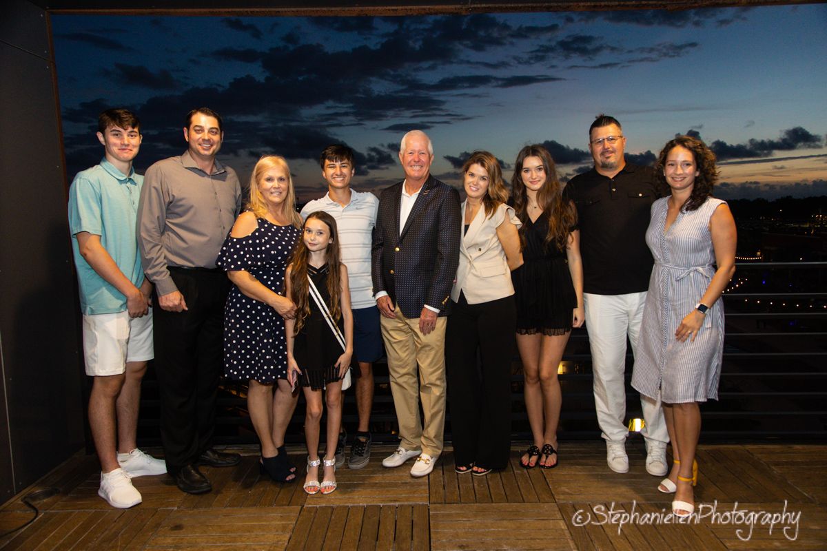 Family group photo taken outdoors at sunset during a special evening celebration event.