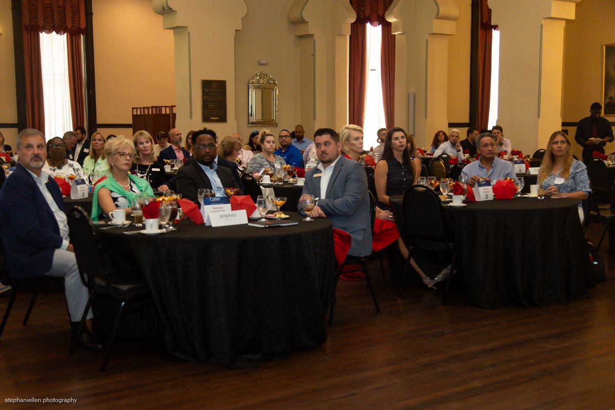 Attendees seated at round tables during a Travelers Institute formal luncheon event.