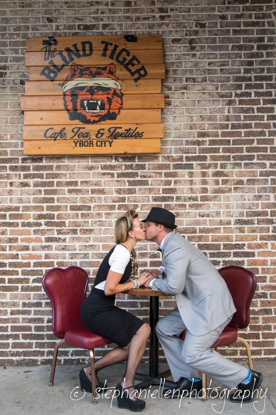 Couple sharing a romantic kiss at a cafe table outside the Blind Tiger in Ybor City.