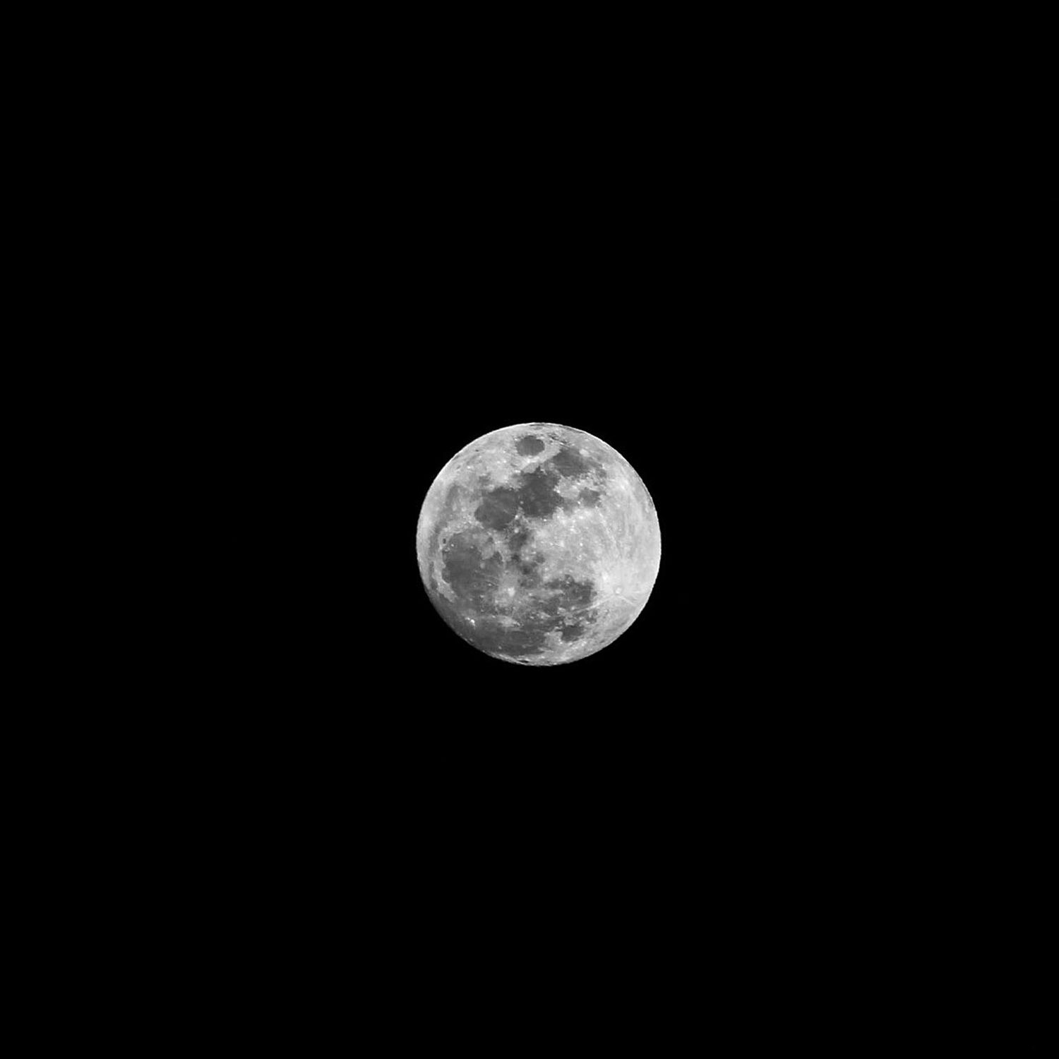 Full moon photographed against a completely black night sky showing detailed lunar surface craters.