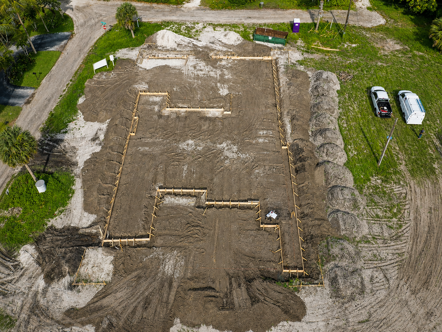 Aerial drone view of rectangular building foundation layout marked in dirt at Florida construction site.
