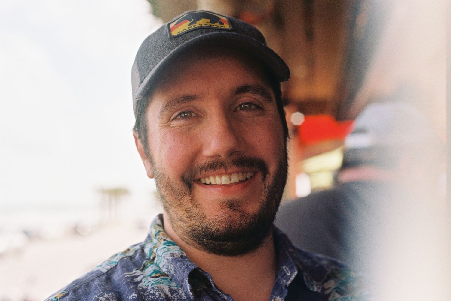 A man smiling for a photo that is on film taken with a camera with a light leak.