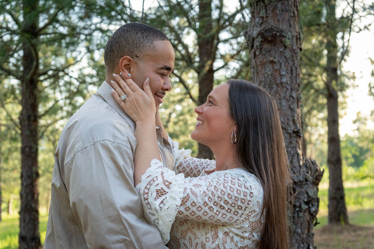 Couple smiling at each other among the trees during a relaxed outdoor couples photography session