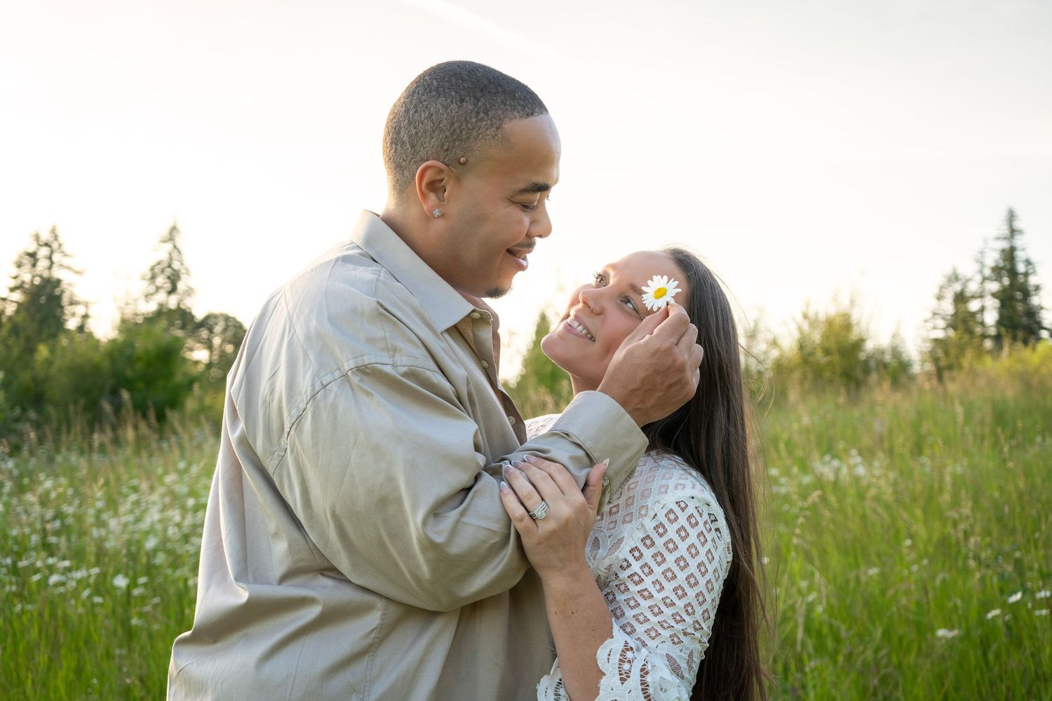 Couple sharing a playful moment with a flower during a golden hour couples photography session in Oregon