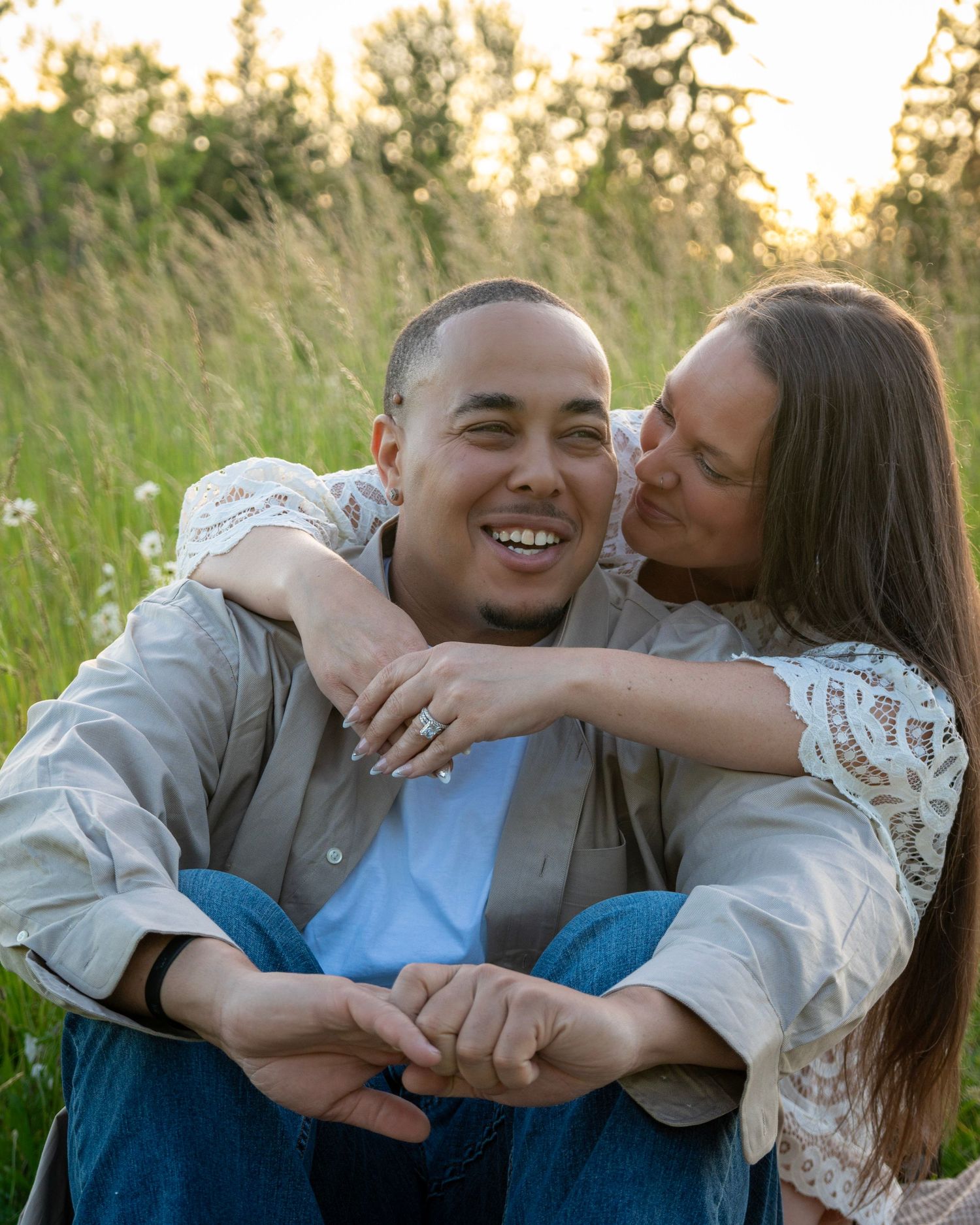 Woman hugging her partner from behind as they laugh together during a candid outdoor couples photography session