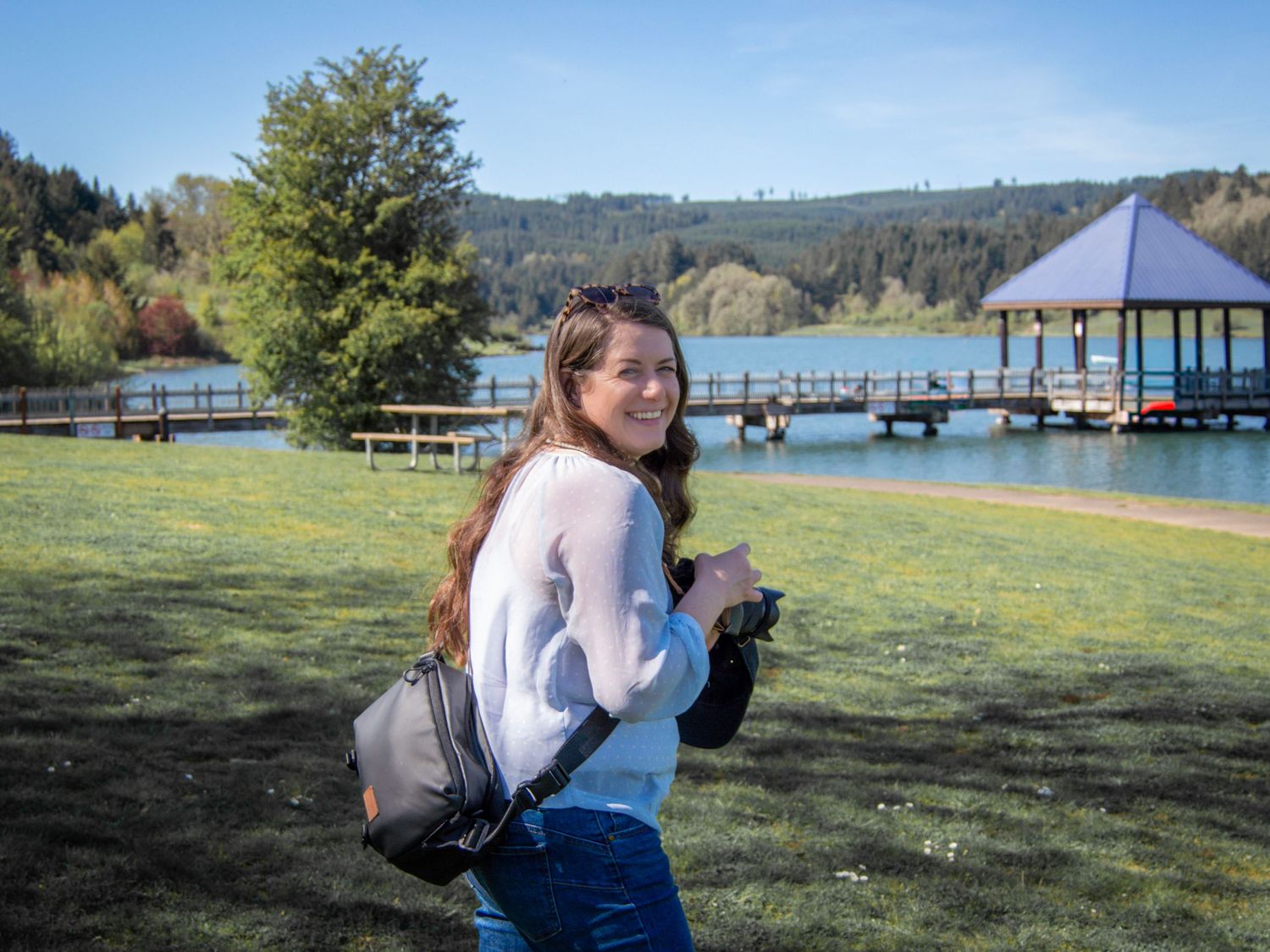 Kate Vargas smiling with her camera gear during an outdoor photography session in Oregon