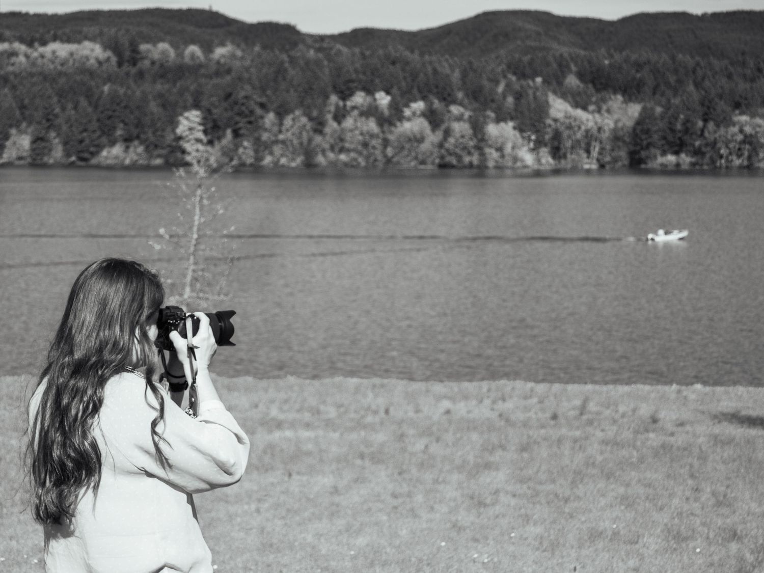 Photographer Kate Vargas taking photos beside a peaceful lake in Oregon