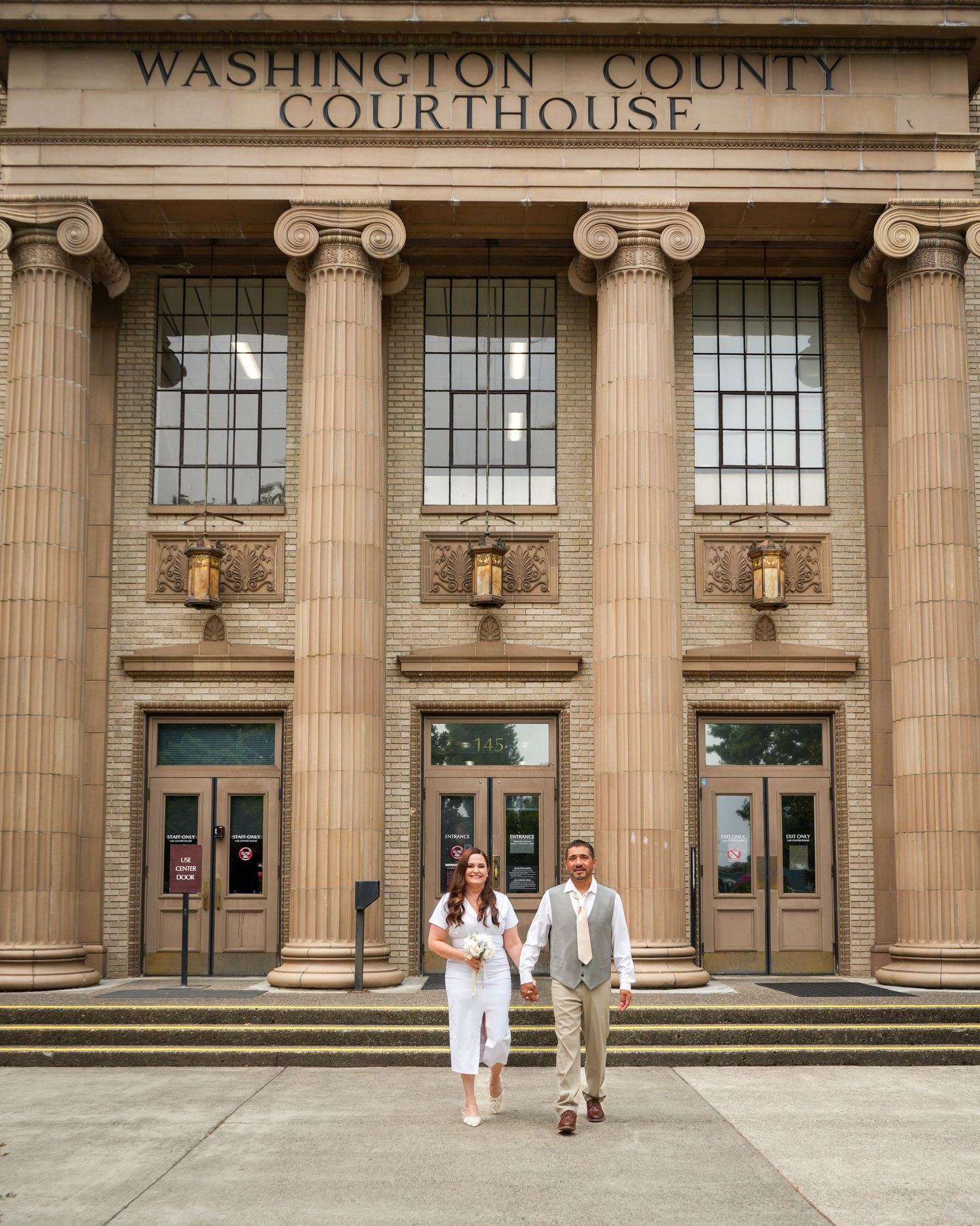 Newlywed couple walking outside the Washington County Courthouse after their wedding.