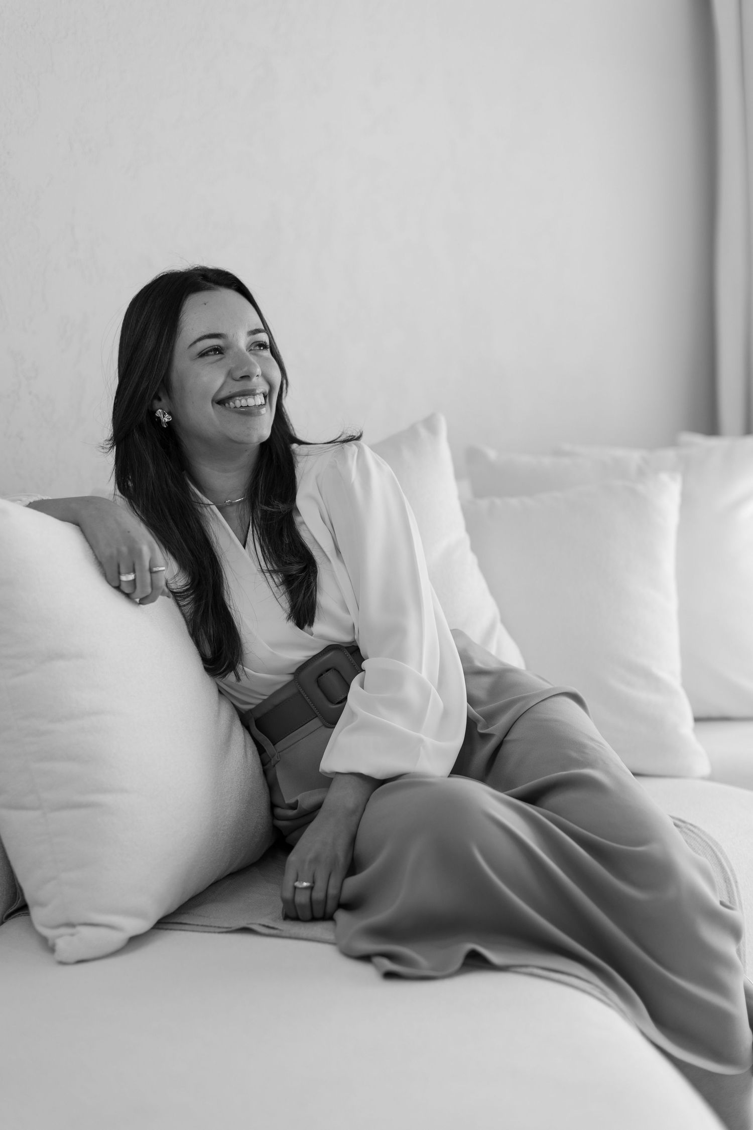 Relaxed black and white portraits on white couch showing natural expressions.