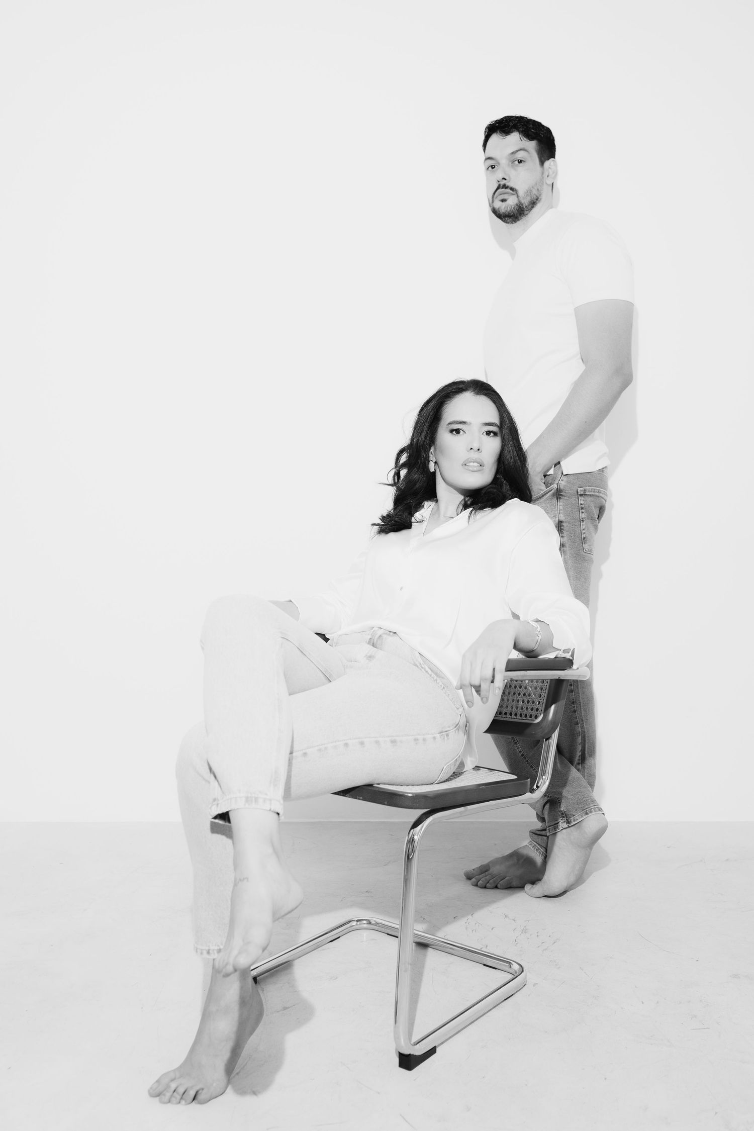 Black and white photo series showing a person sitting in a modern chair against a white backdrop.