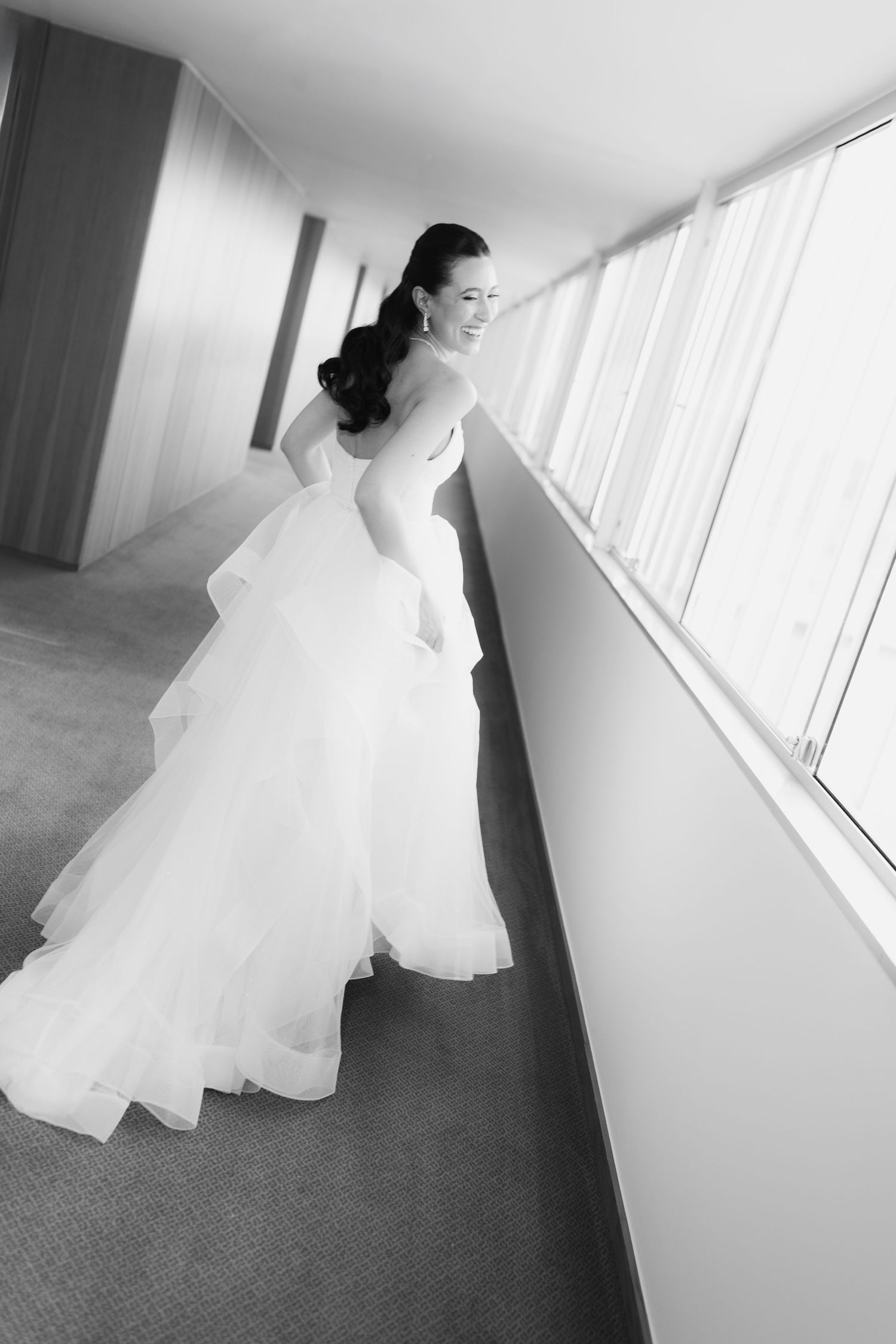 Artistic motion shots of flowing white wedding dress in minimalist hallway.