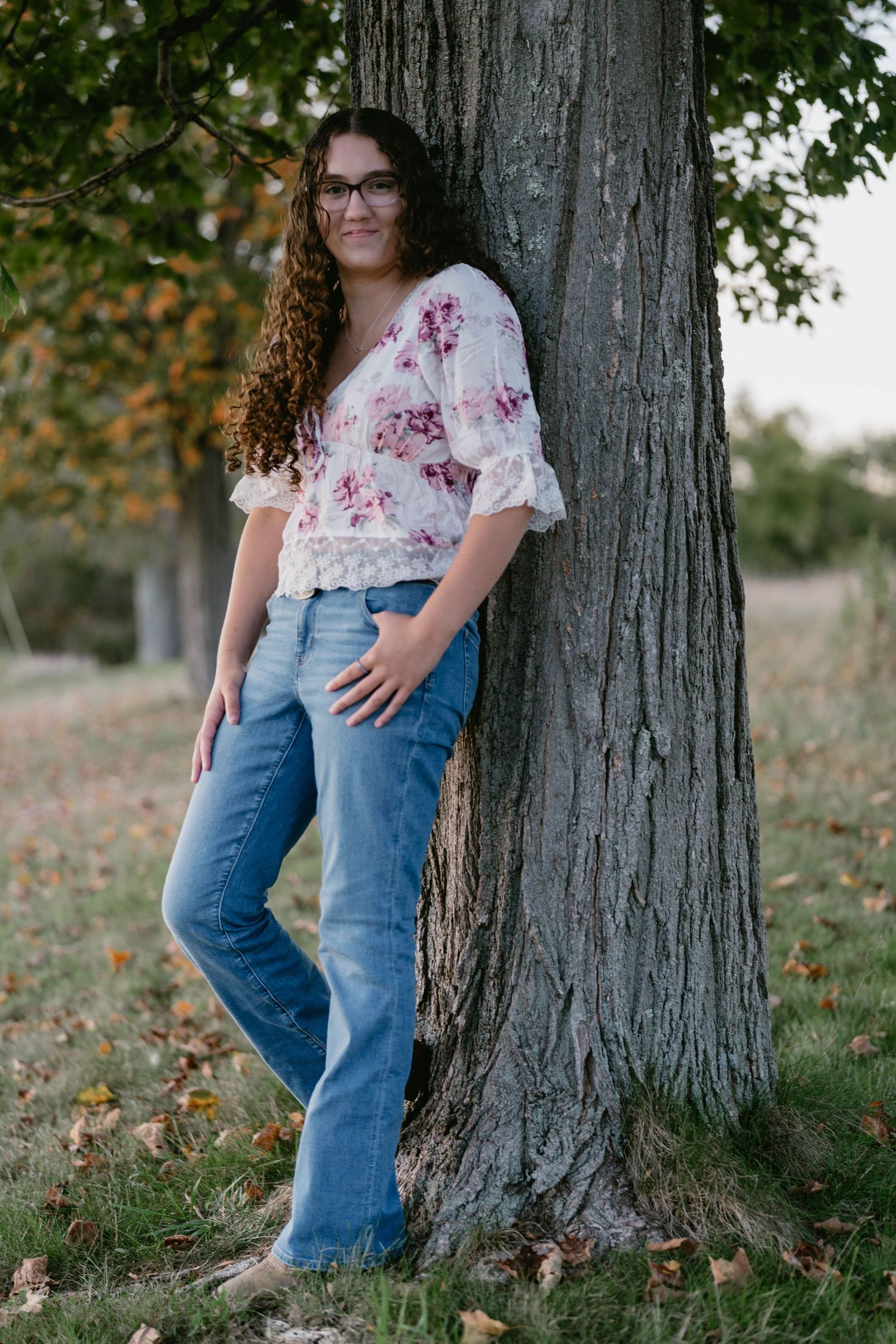 Teen walking along a path through a long grassy meadow, relaxed pose.