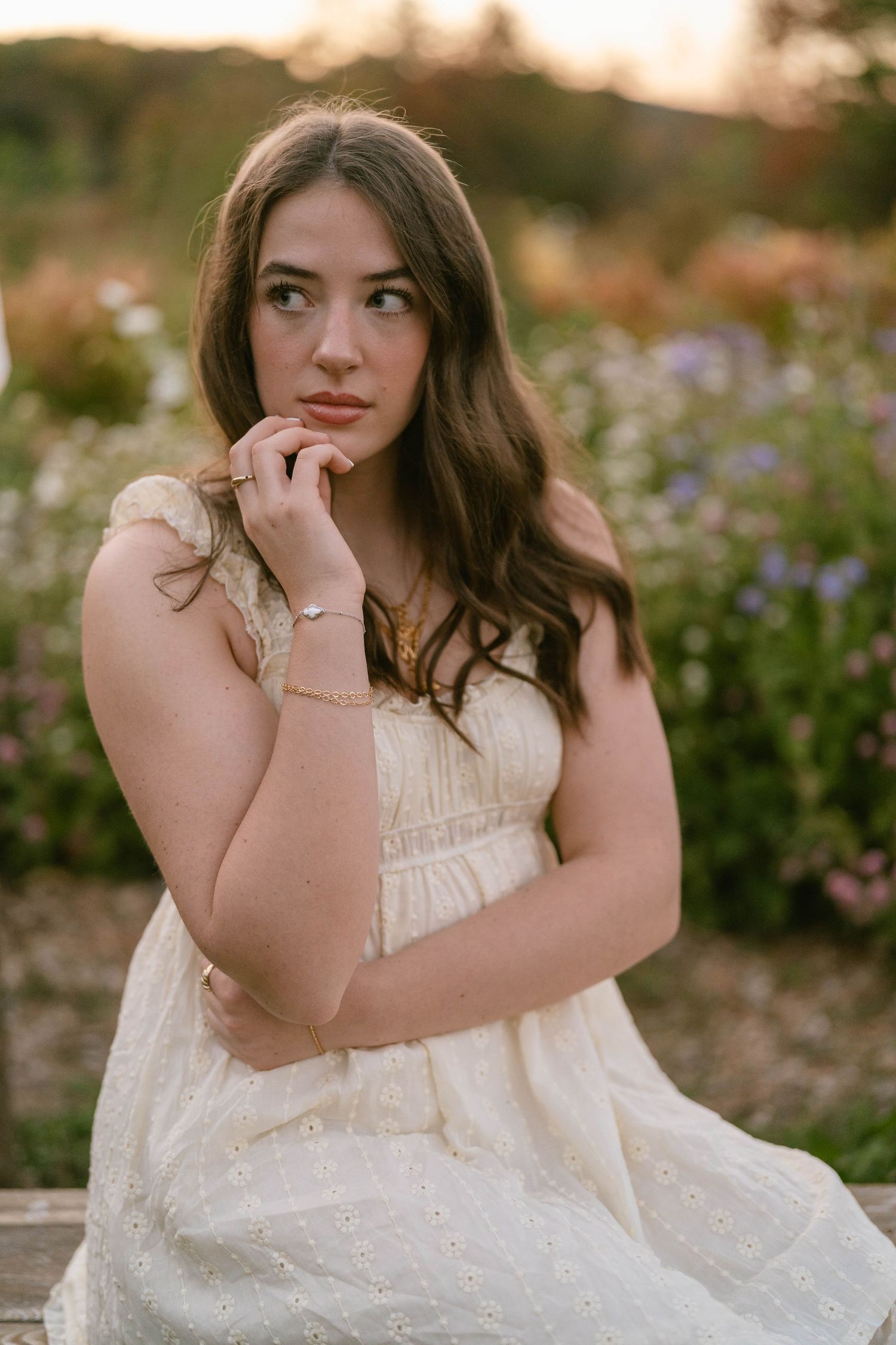 Senior looking back over shoulder while walking through flower field, playful pose.