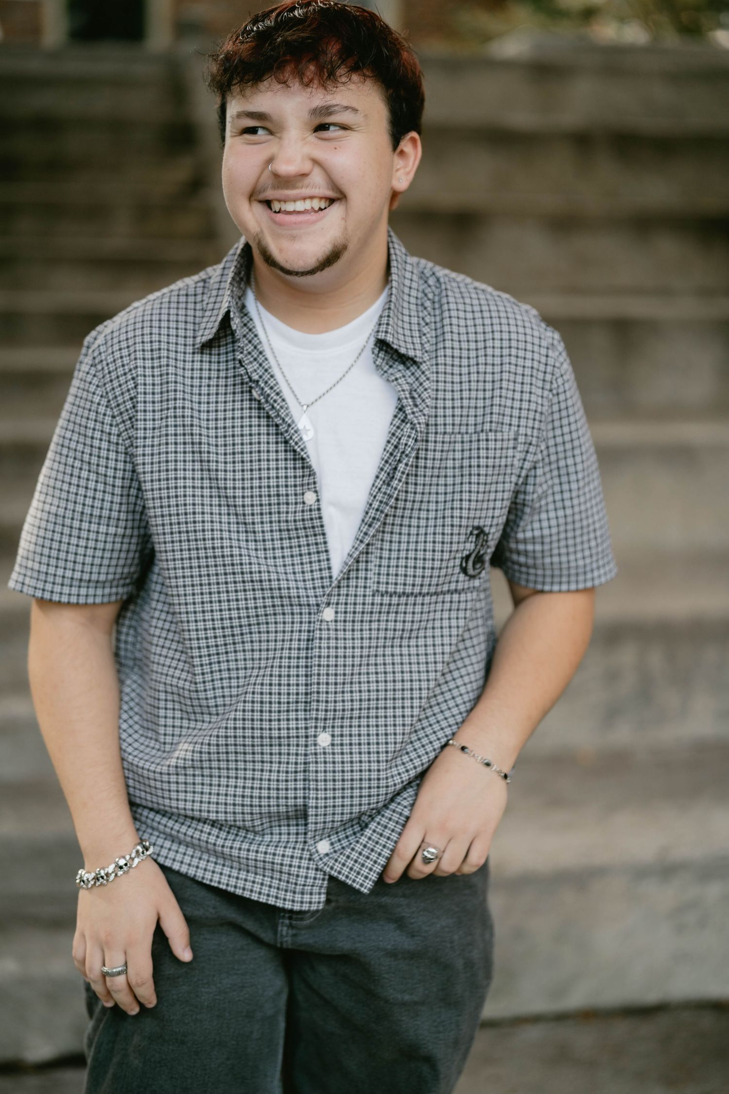 Teen laughing on city steps, enjoying a fun and lighthearted senior session