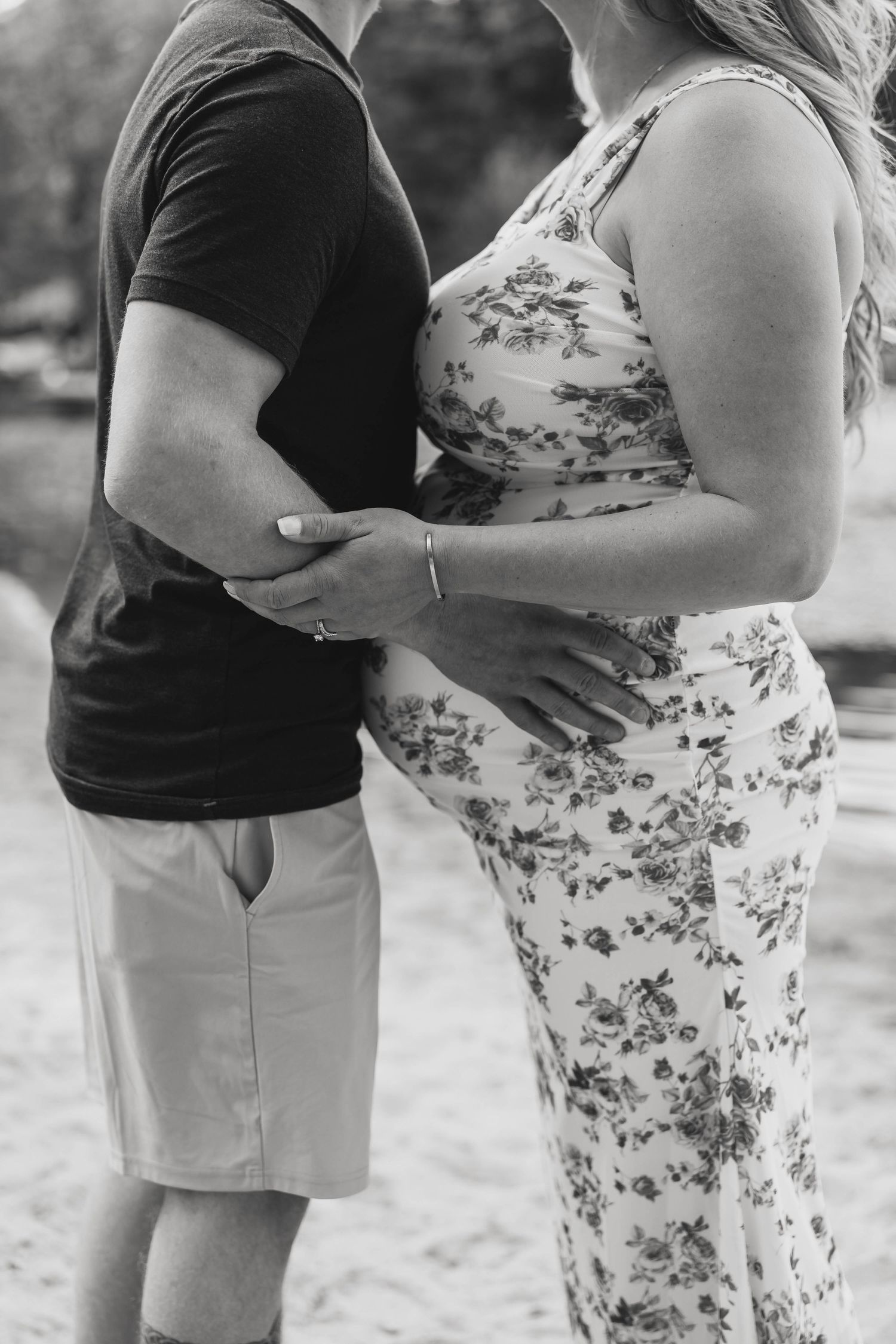 Black and white photos showing tender pregnancy moments on a beach.