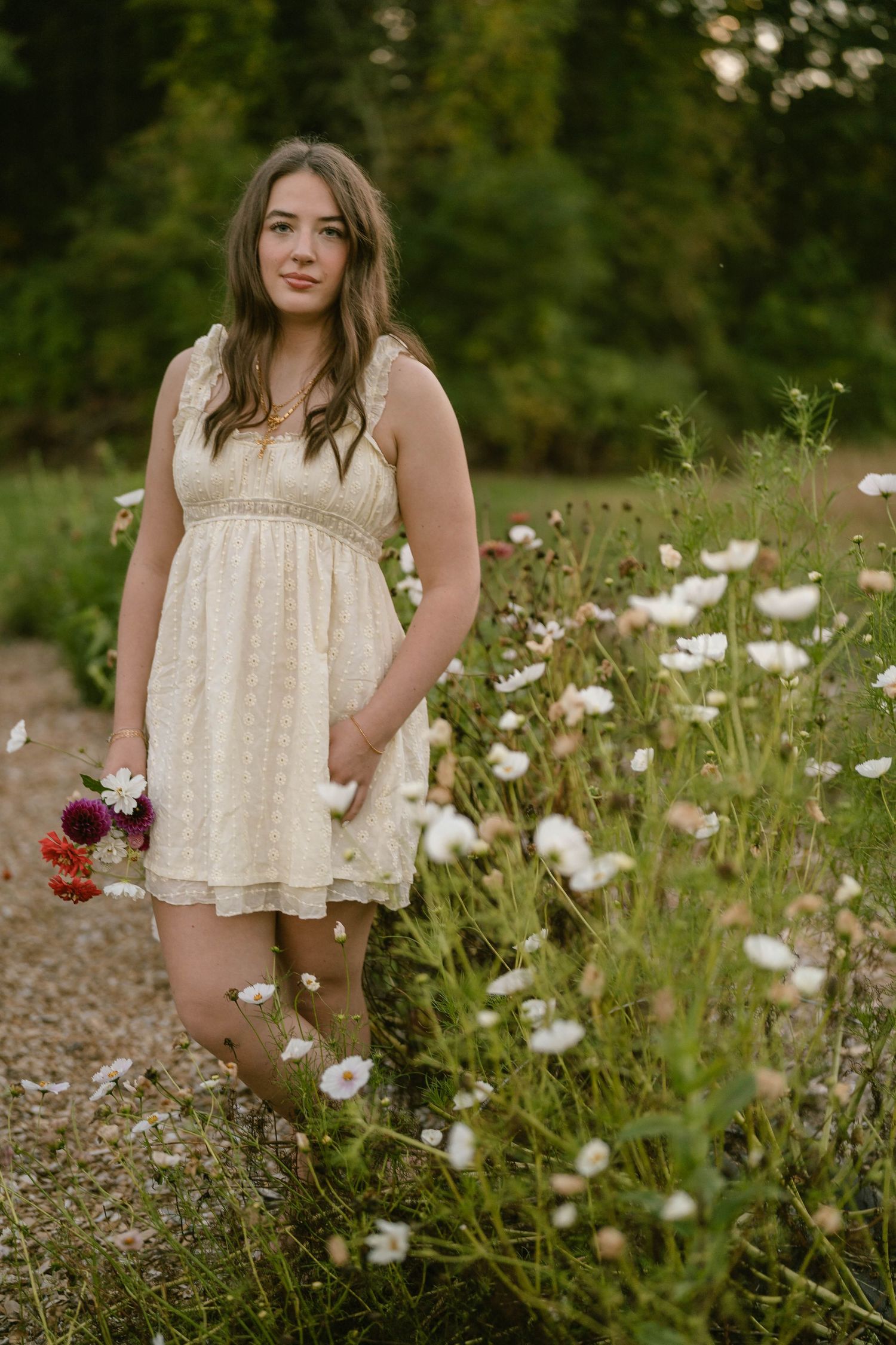 Teen twirling with flowers in hand, captured in vibrant outdoor portrait.