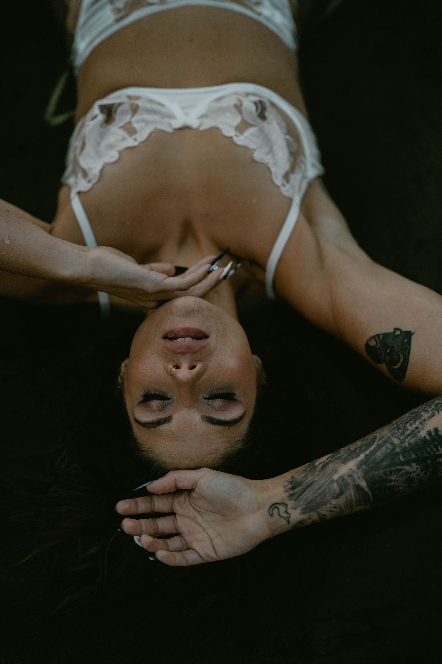 Dramatic black and white boudoir photo with delicate lace details and artistic composition.
