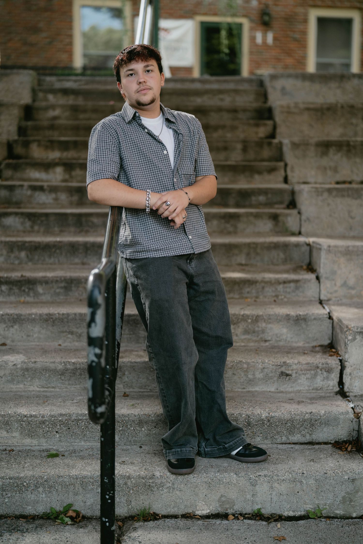 Teen portrait near street lamp and brick wall, natural and casual pose.