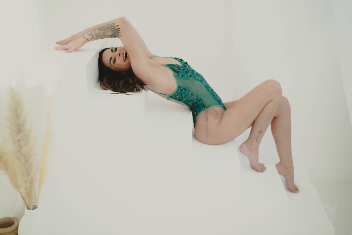 Elegant pose on white background with pampas grass decor and green lace details.