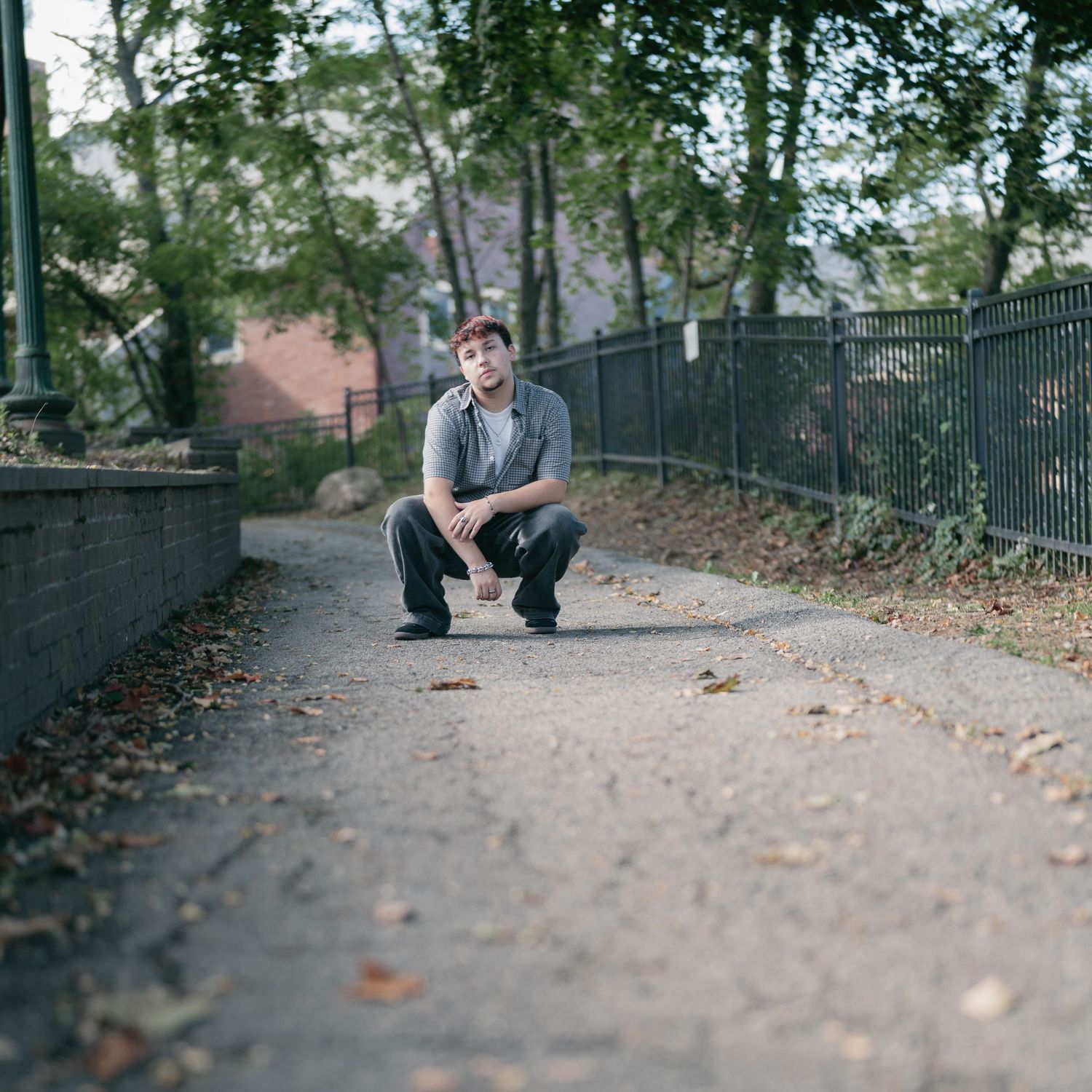 High school senior walking down street, relaxed and confident in urban setting.
