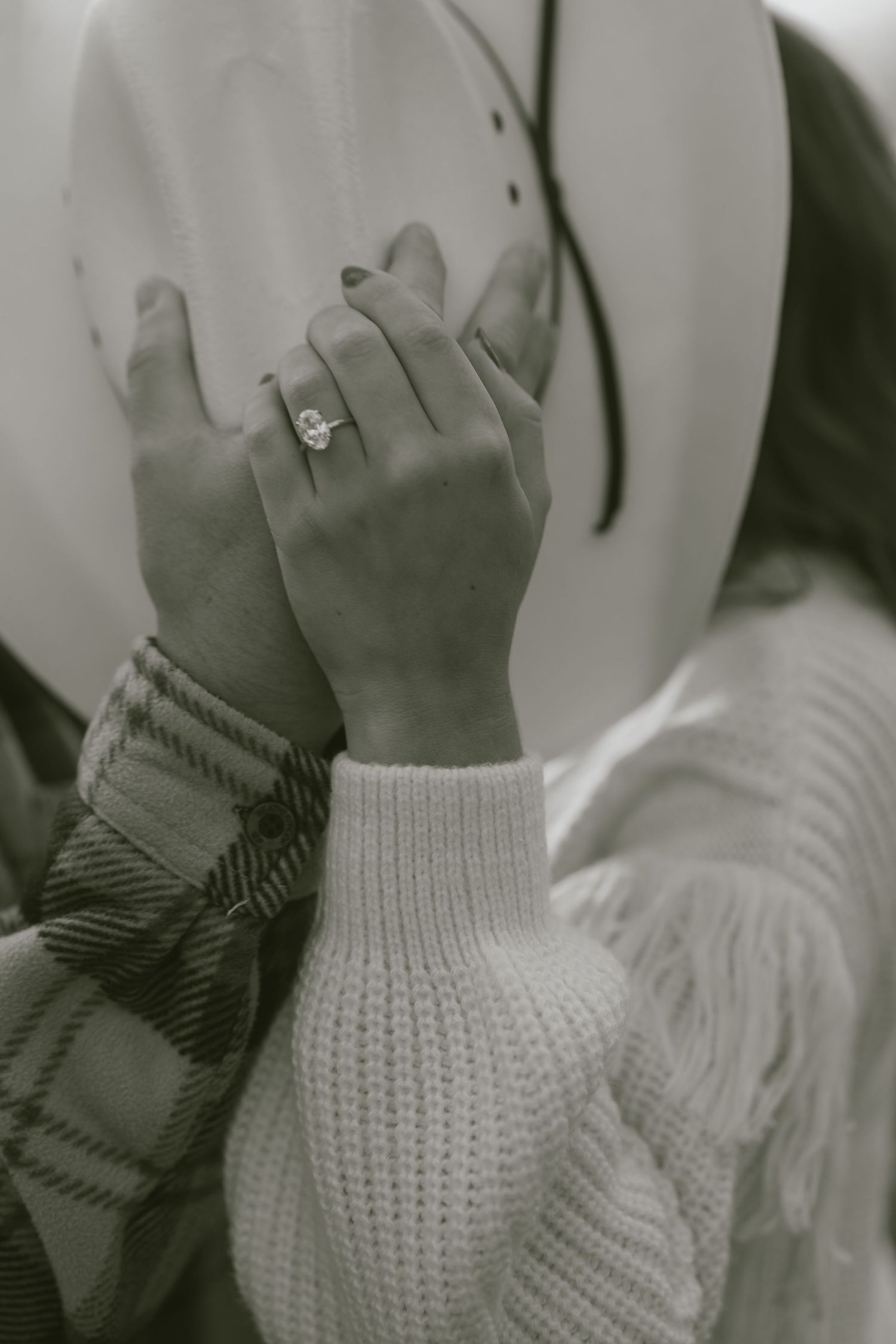 A series of black and white photos showing hands wearing a white knit sweater sleeve and a plaid bow accessory.