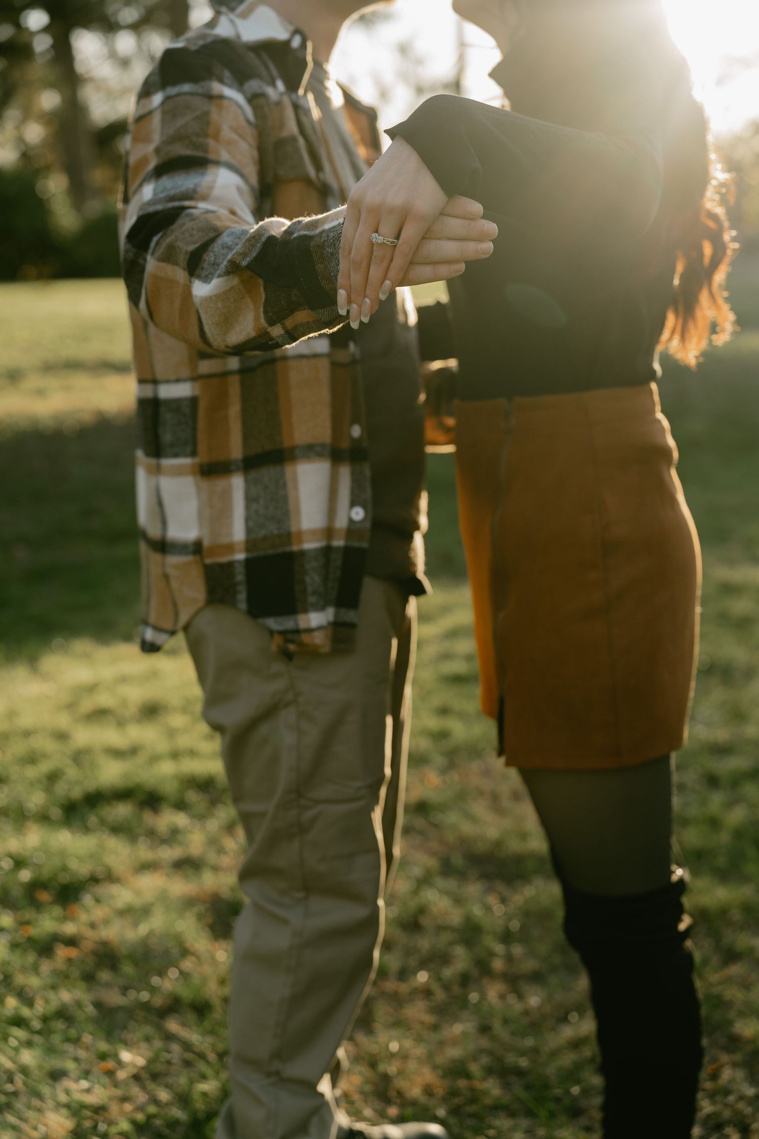 Sun-drenched autumn scene showing a tender moment between two people in casual attire.