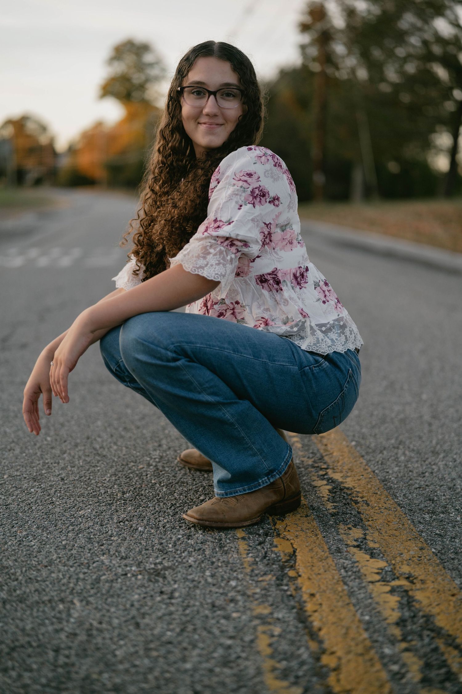 High school senior standing in crosswalk, smiling during street session.
