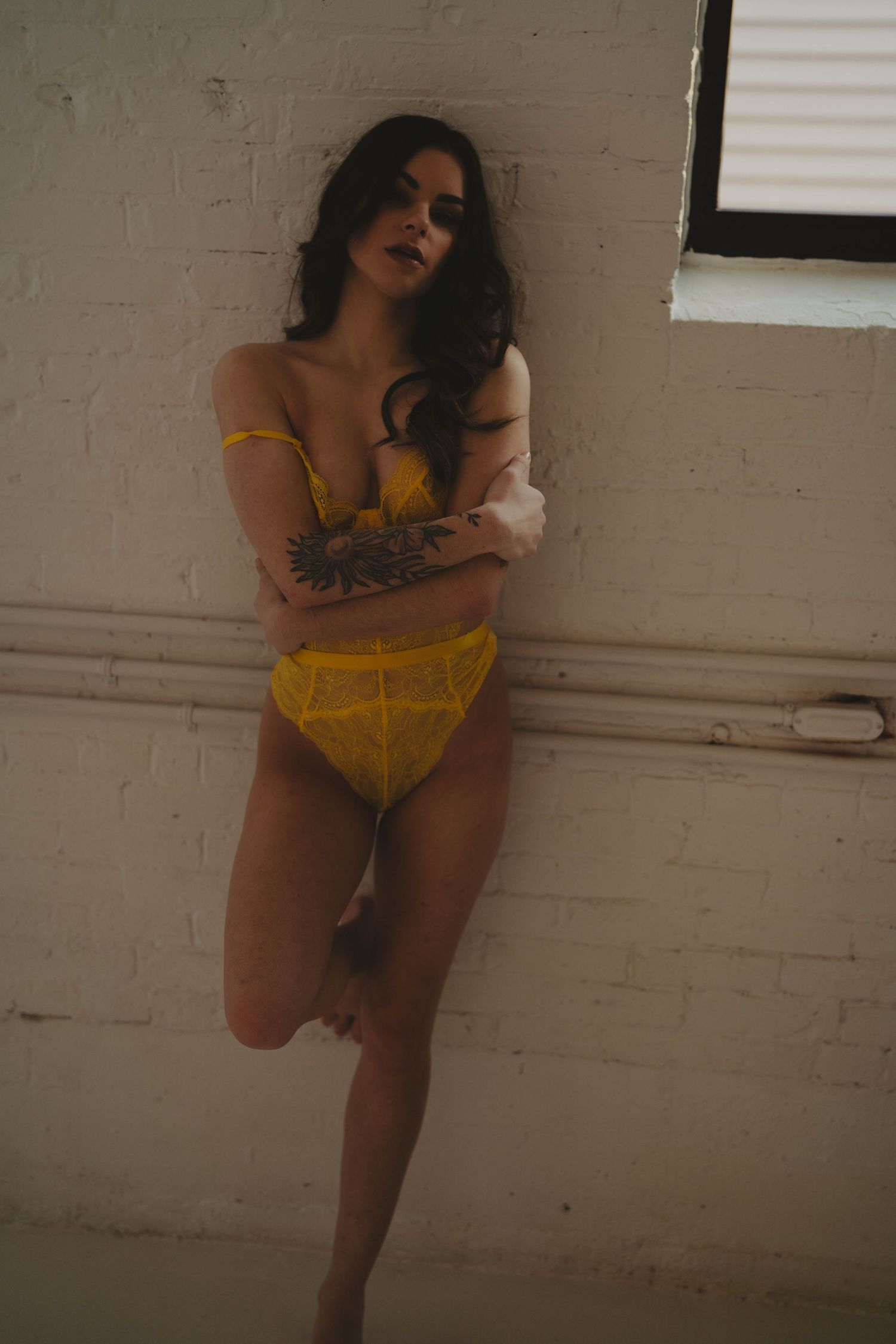 Artistic boudoir photography with vintage aesthetic and yellow lace details.