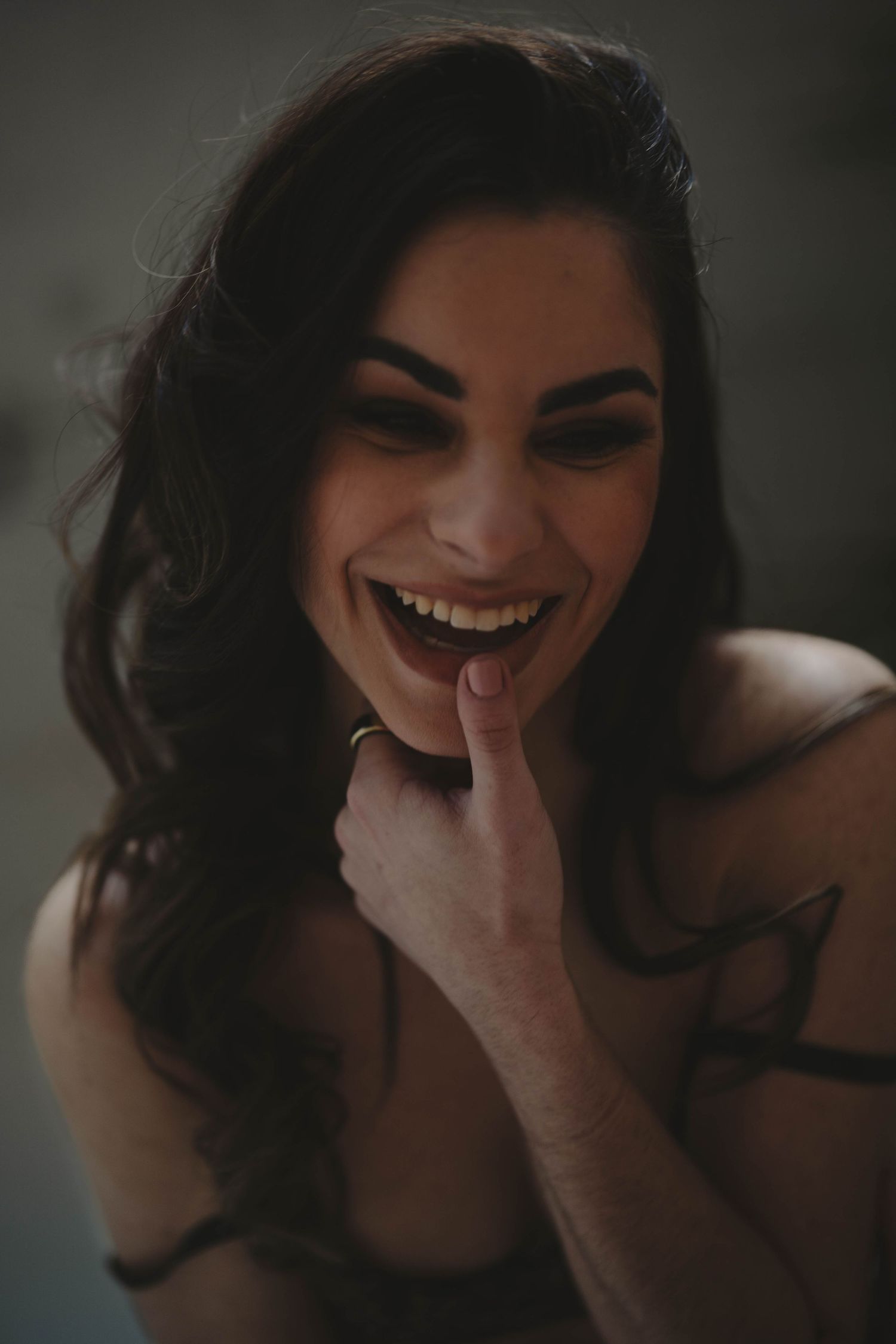 A sequence of candid portraits showing joyful laughter and genuine emotion in moody lighting.