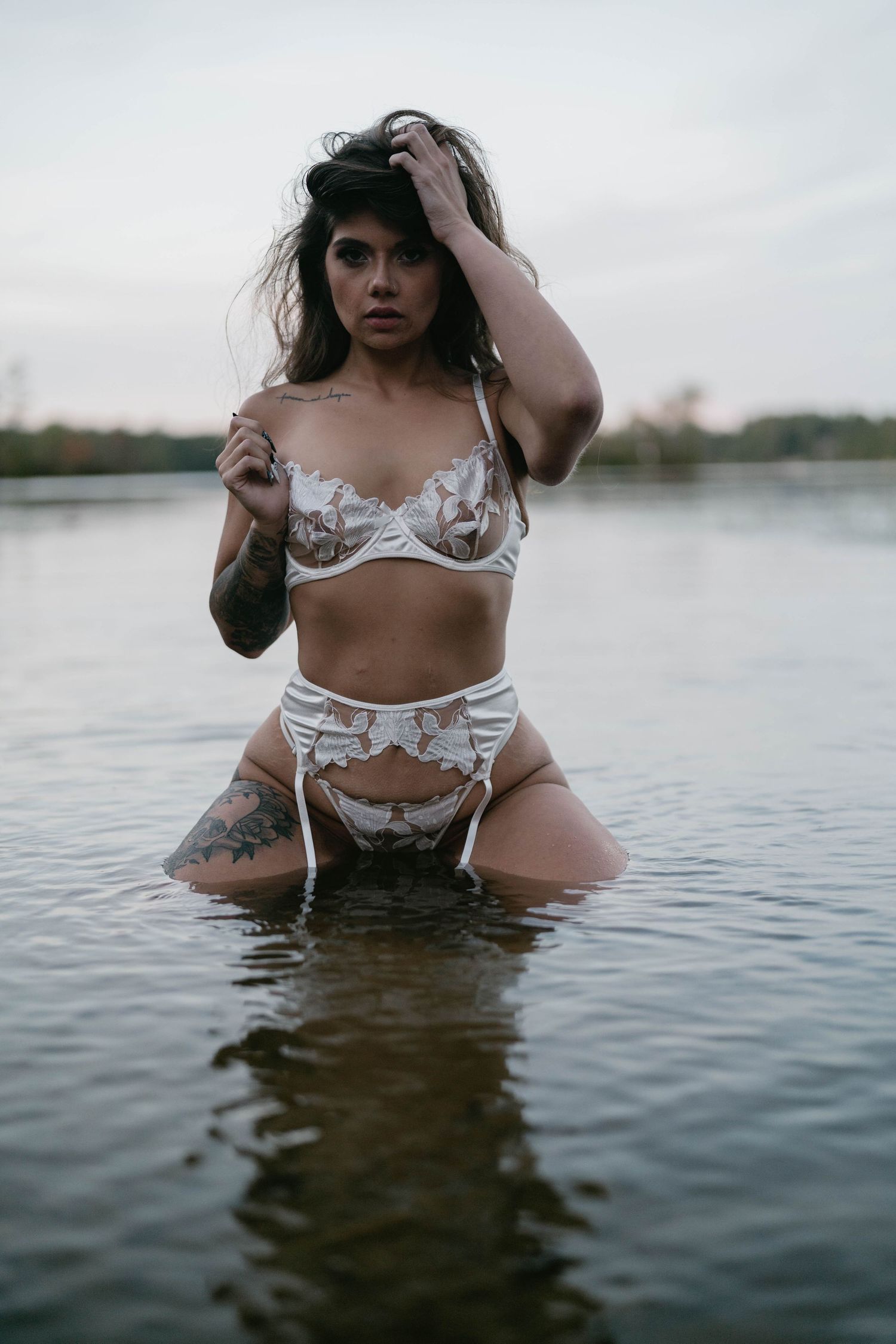 White lingerie photoshoot in shallow water with natural lighting.