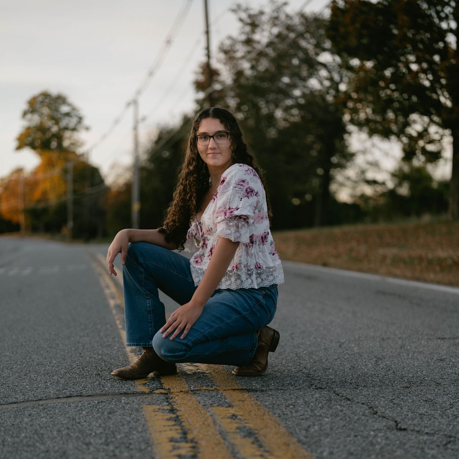 High school senior standing in crosswalk, smiling during street session.