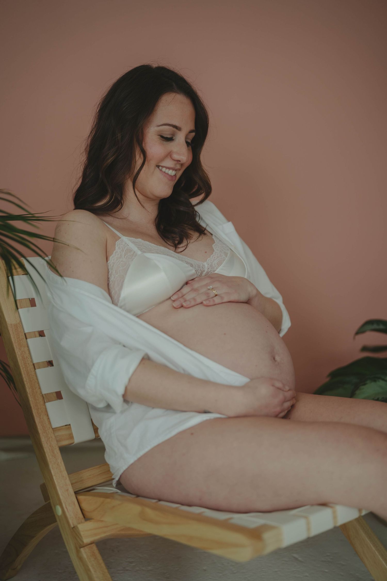 Intimate maternity boudoir photos in warm tones with natural lighting.