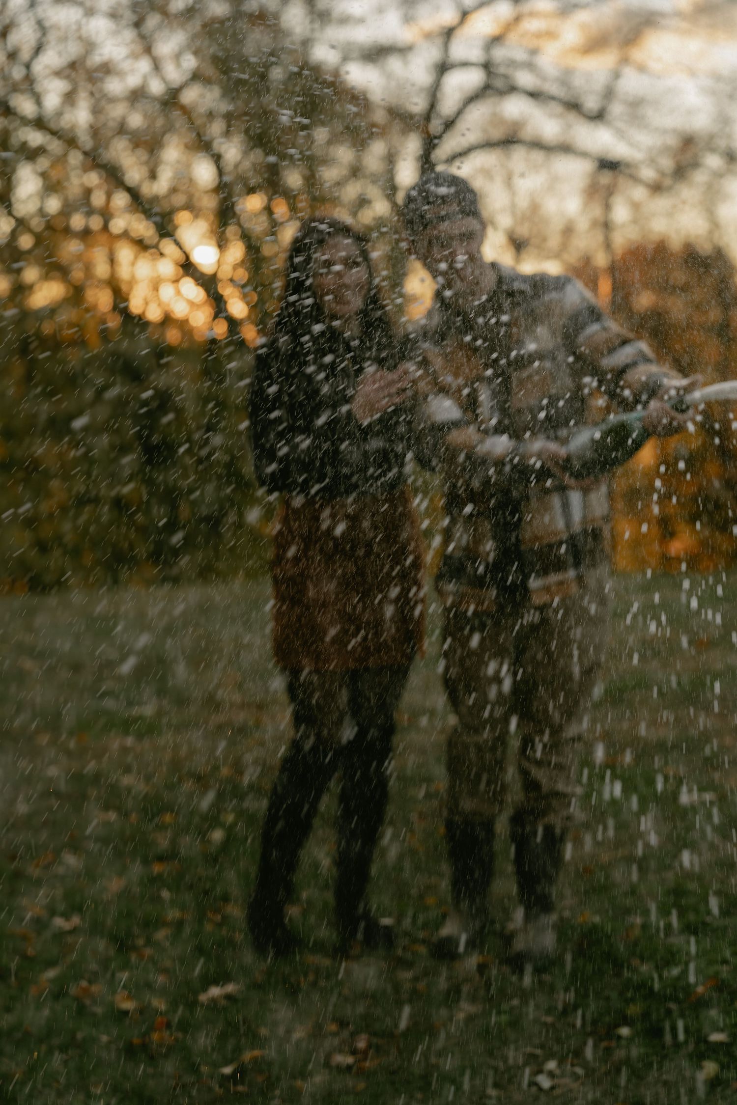 Silhouettes celebrate with champagne spray against an autumn sunset backdrop.