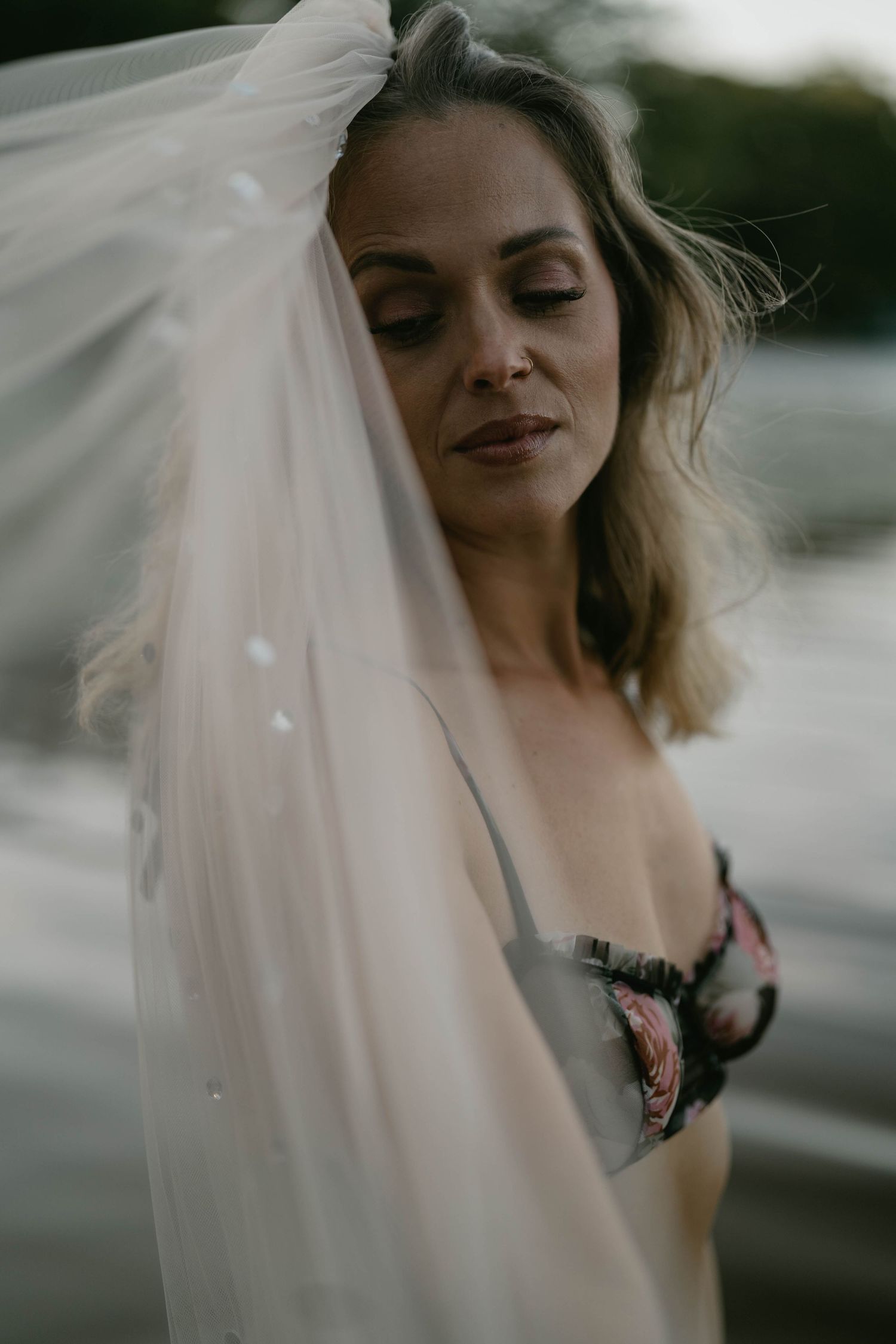 Ethereal boudoir photography session with flowing sheer fabric and moody lighting.