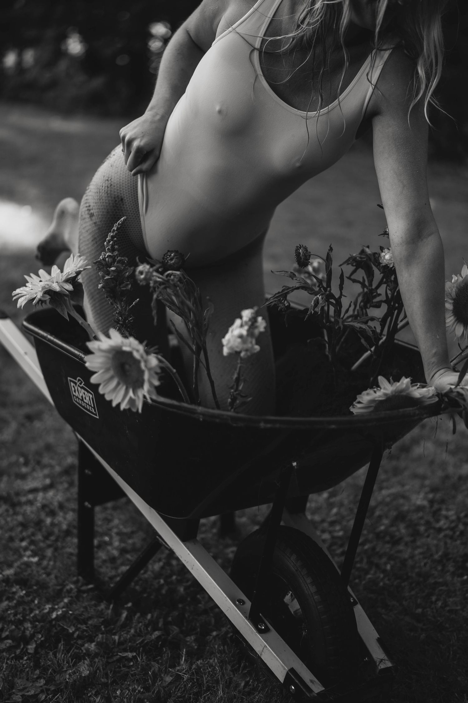 Artistic black and white composition featuring flowers and a vintage suitcase prop.