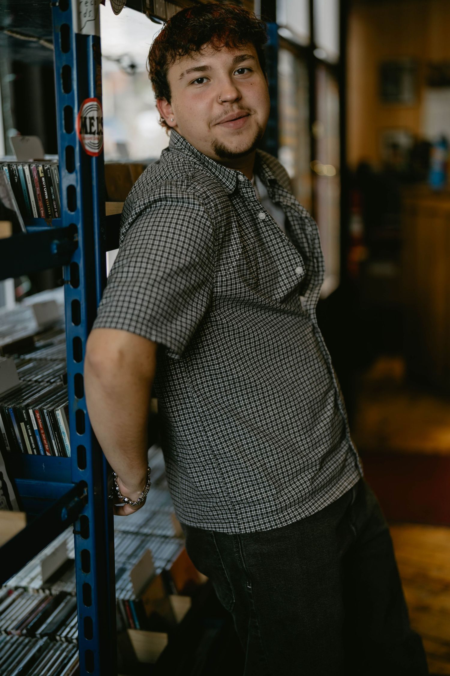 Teen enjoying time in record shop, captured naturally during senior session.