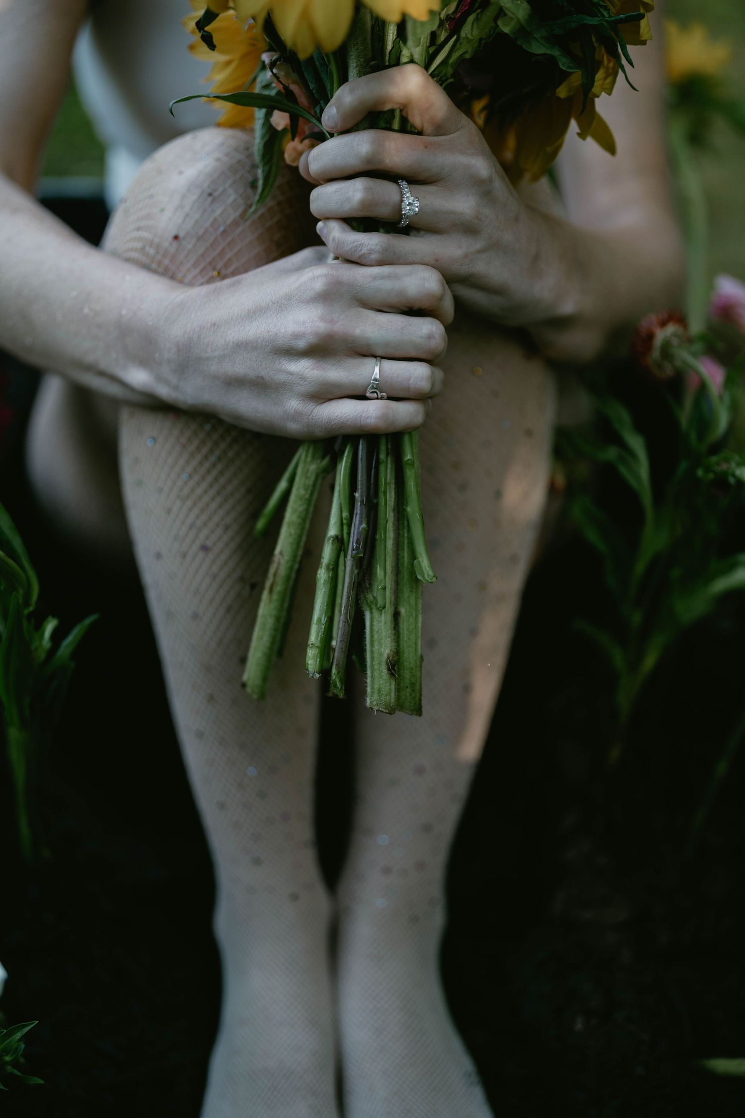 Close-up of hands holding a fresh bouquet of flowers with soft natural lighting.
