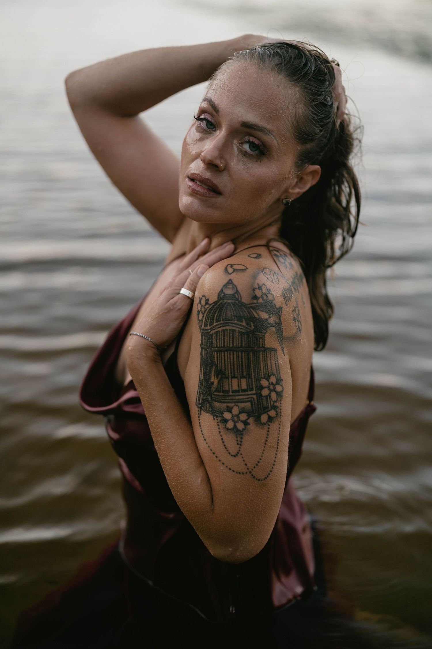 Artistic portraits showcasing intricate tattoo designs in natural water setting.