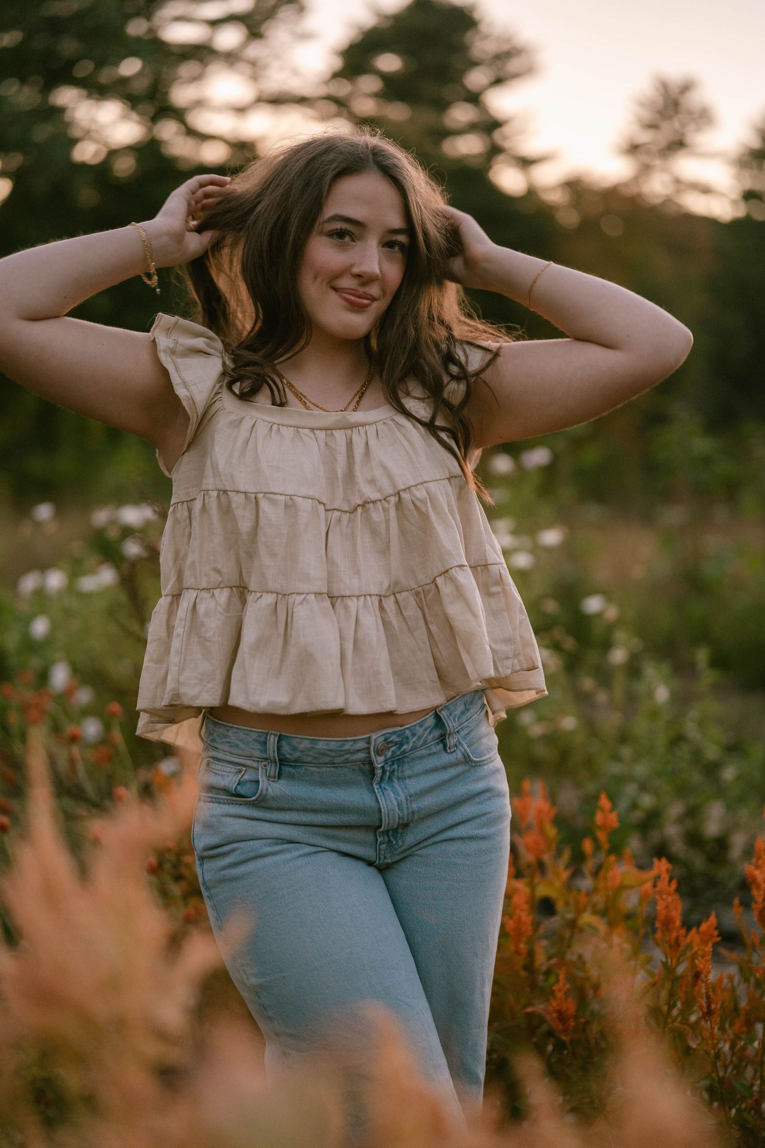 Senior leaning among flowers, relaxed and joyful during outdoor portraits.