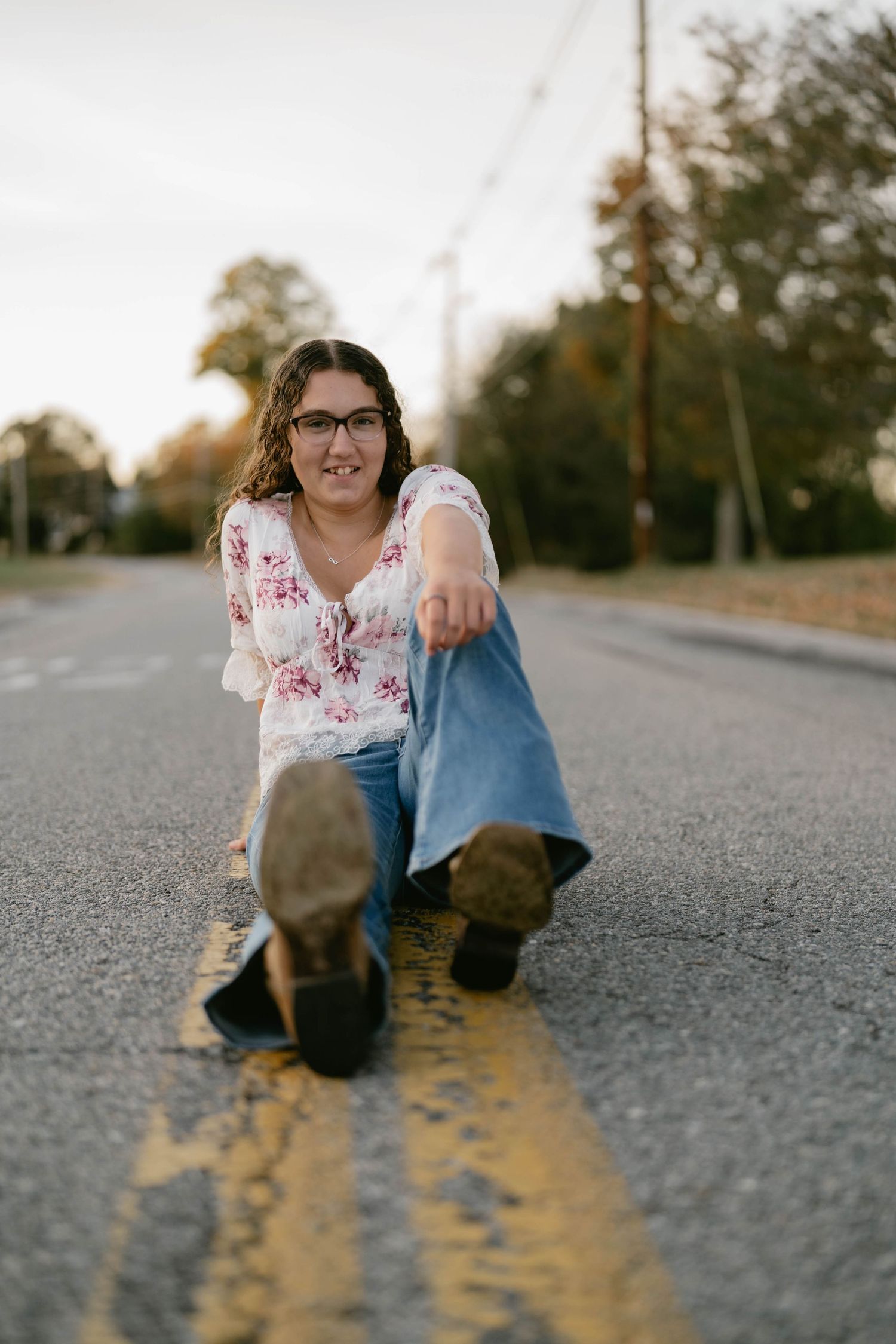 High school senior standing in crosswalk, smiling during street session.