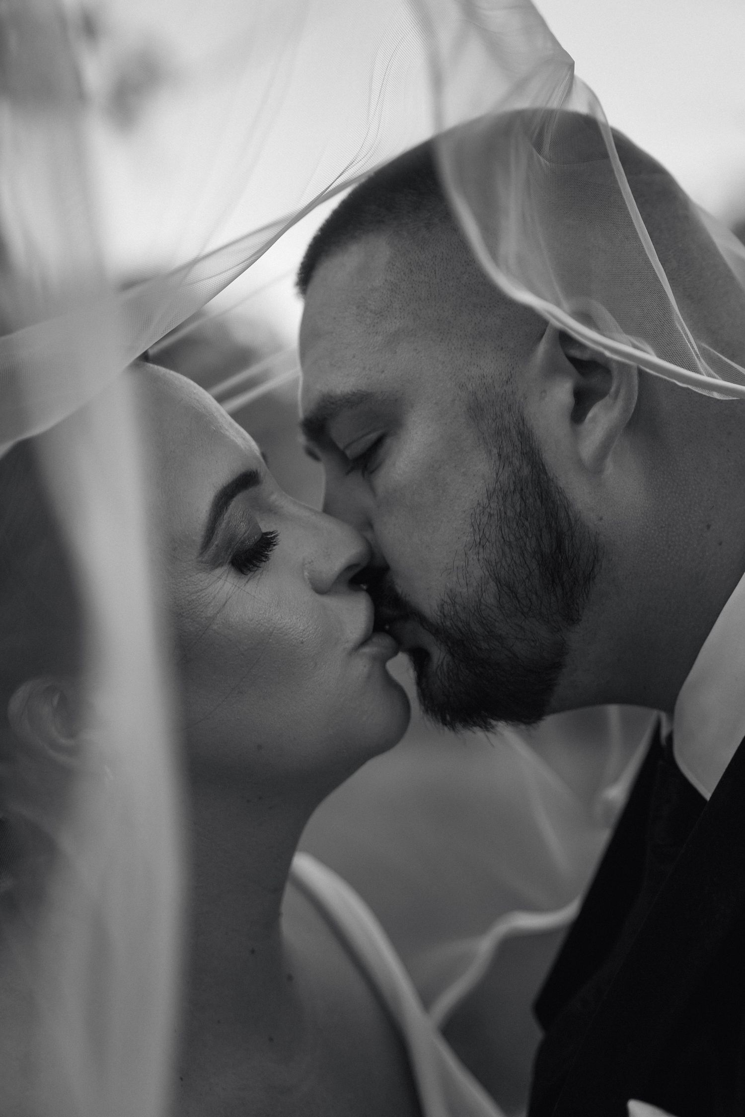 A romantic black and white photo sequence showing a couple in an intimate moment sharing a tender kiss.