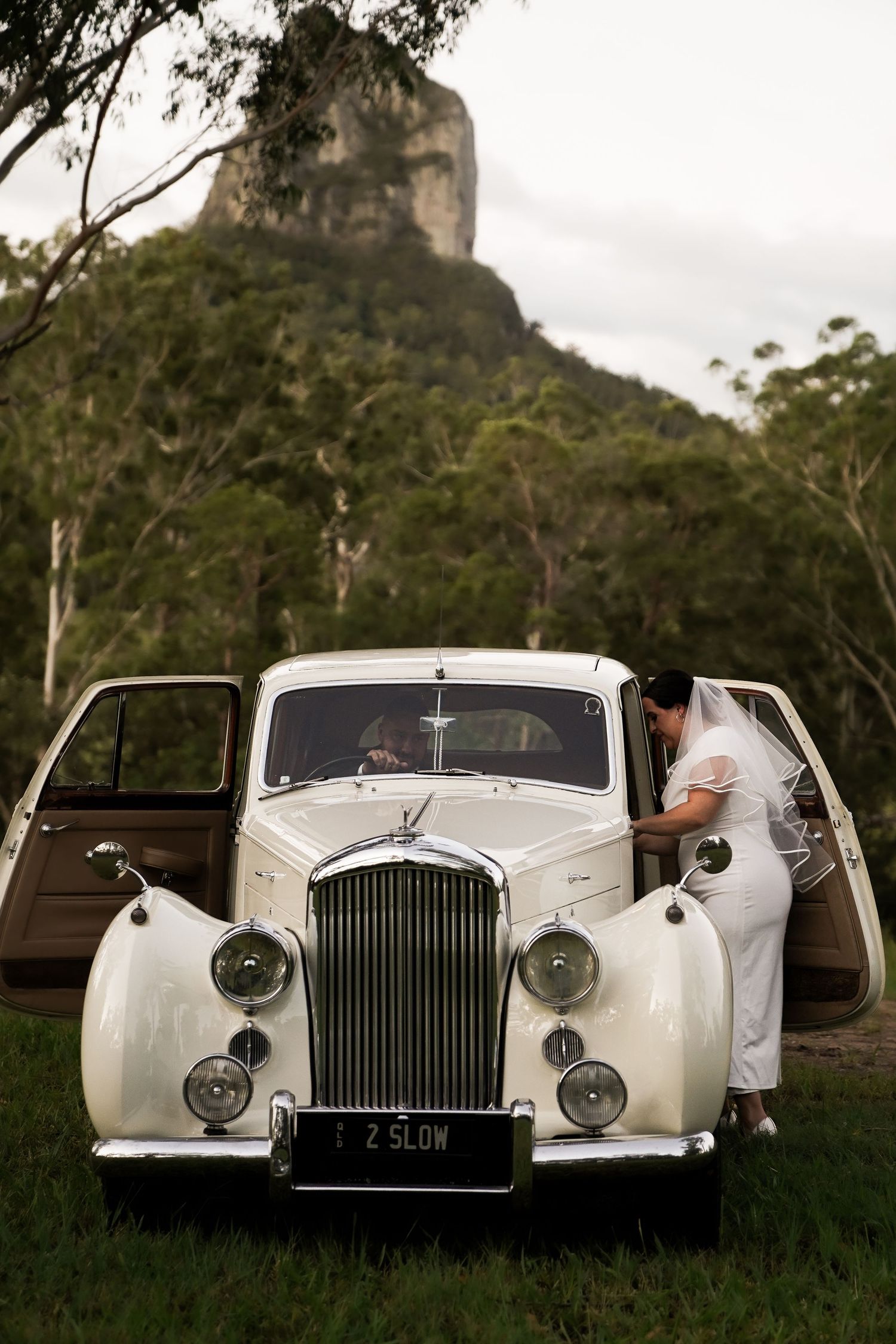 A vintage white Rolls Royce wedding car photographed from multiple angles in a scenic mountain setting.