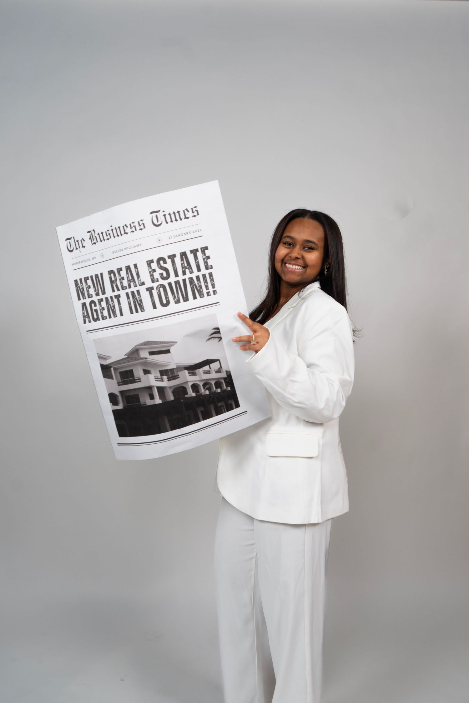 Smiling woman in white suit holding a Business Times newspaper headline reading New Real Estate Agent In Town.