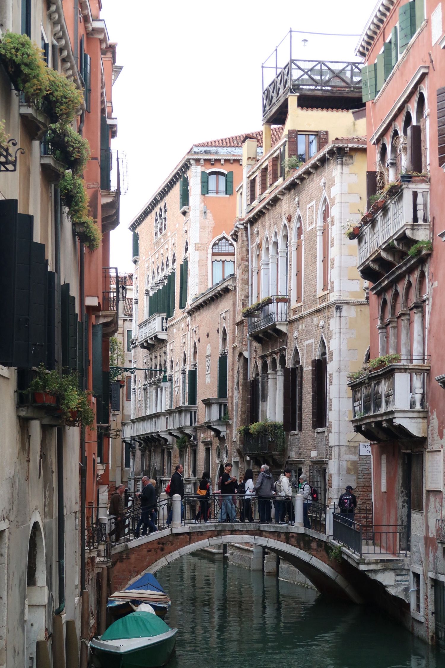 A picturesque Venice canal with traditional architecture and a small bridge crossing over turquoise water, travel photography, venice italy
