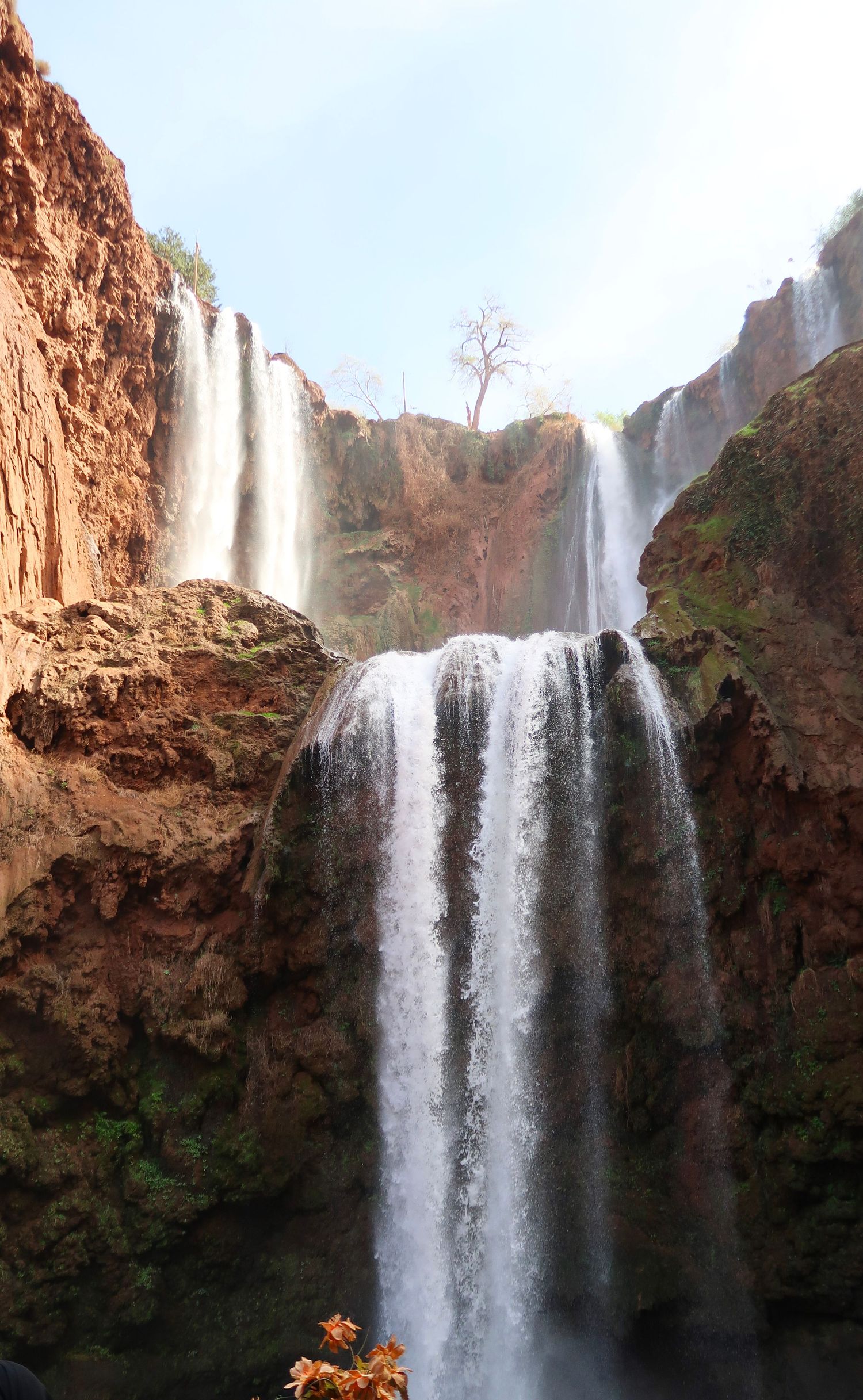 Majestic waterfall cascading down red rock cliffs in a scenic natural landscape.