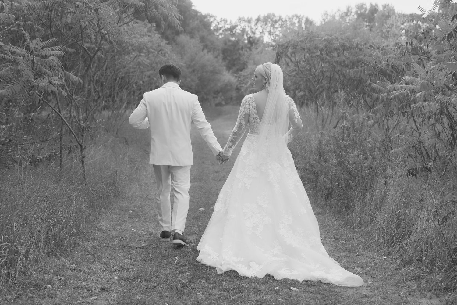 Wedding couple takes romantic black and white portraits in a natural outdoor setting.