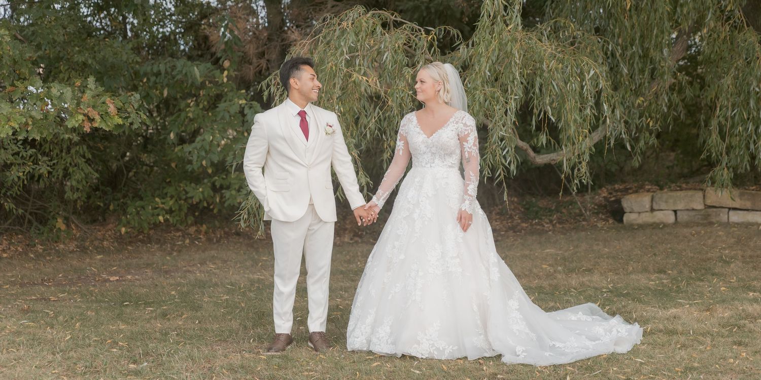 A wedding couple poses for romantic outdoor photos in a garden setting with natural light.